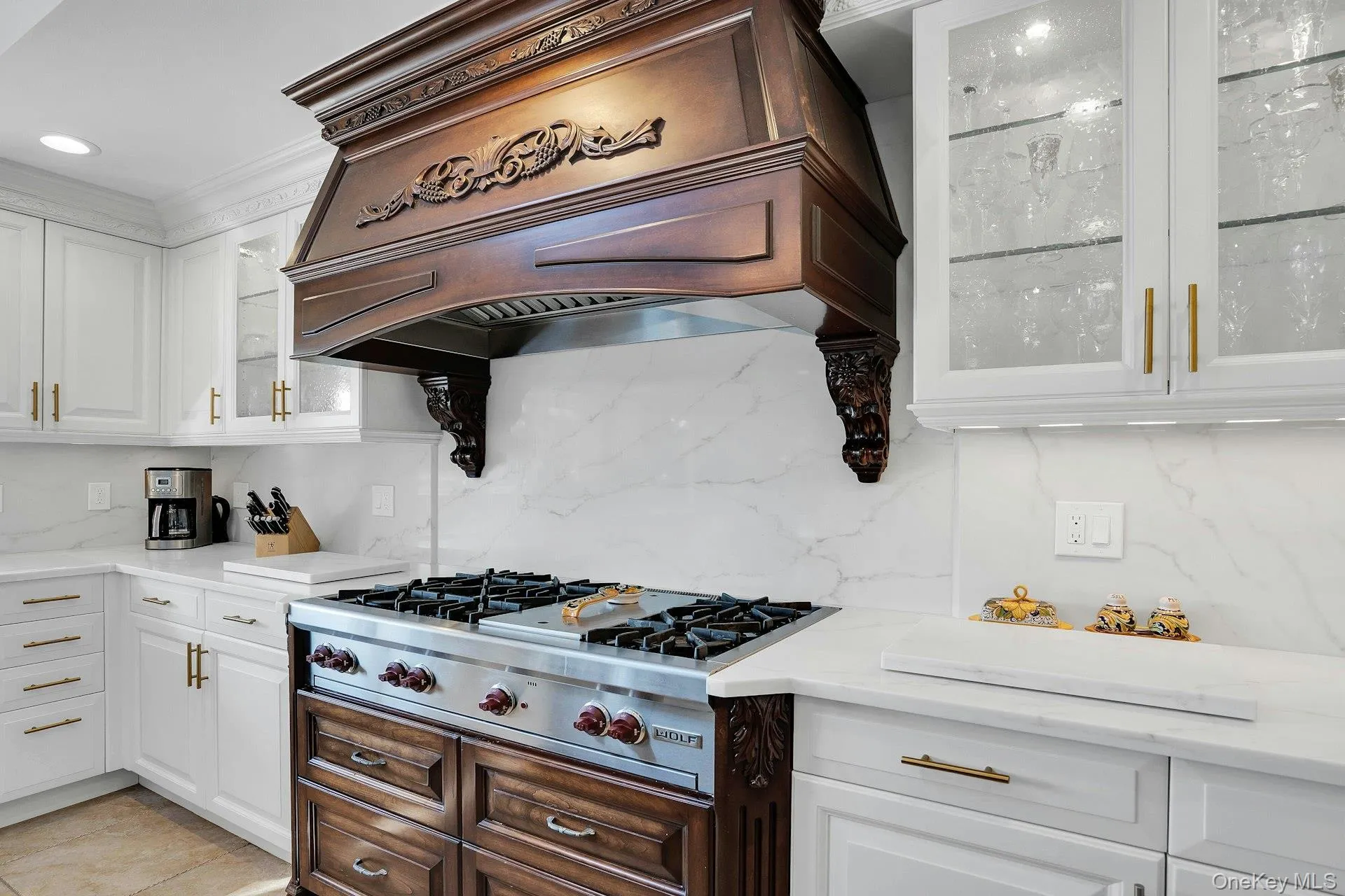 Wolf stove with 6 burners and grill. Custom carved hood is a showpiece. Wolf stove with 6 burners and grill. Custom carved hood is a showpiece.