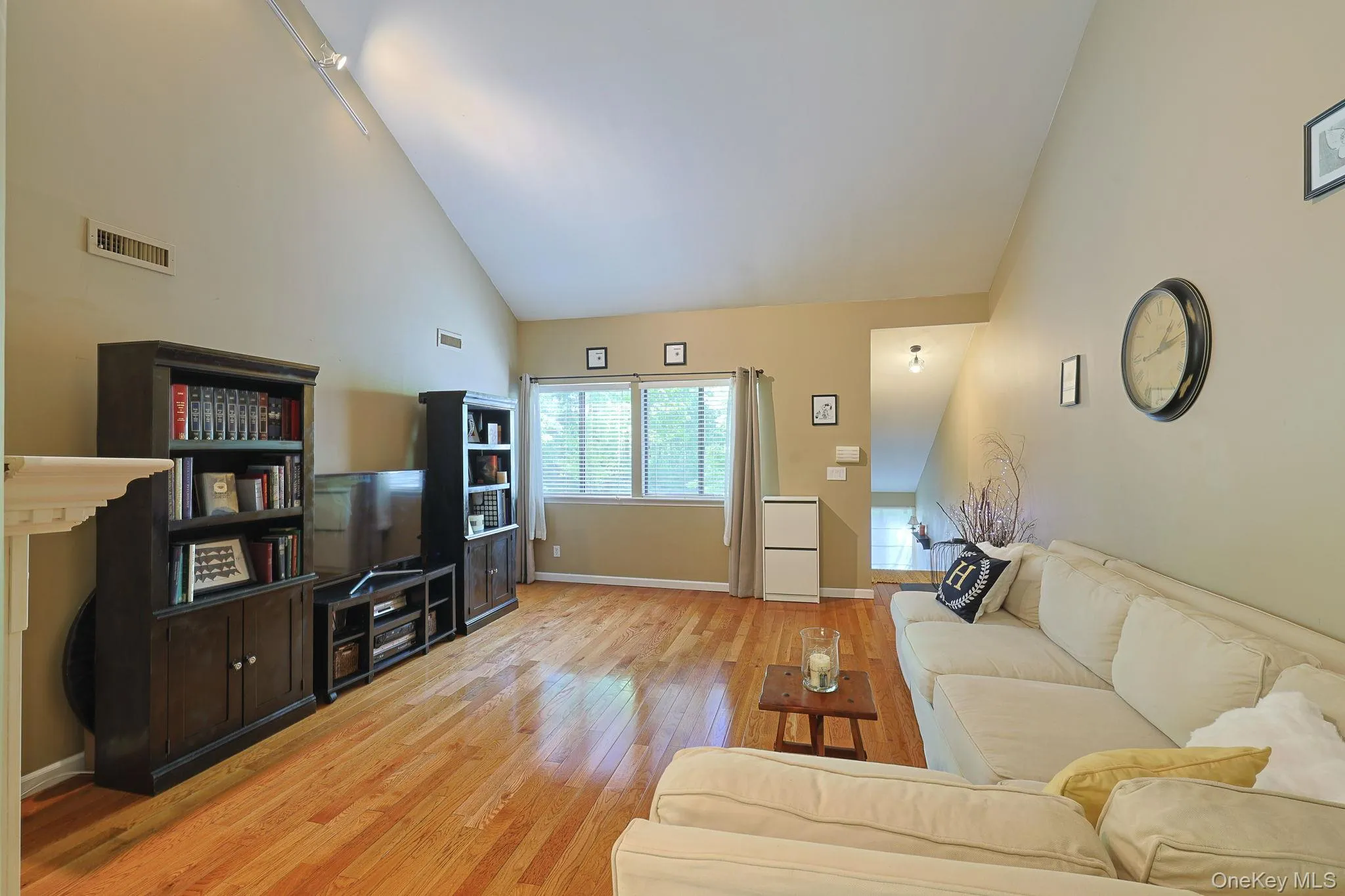 Living room featuring windows with natural light, hardwood flooring and the front entrance Living room featuring windows with natural light, hardwood flooring and the front entrance
