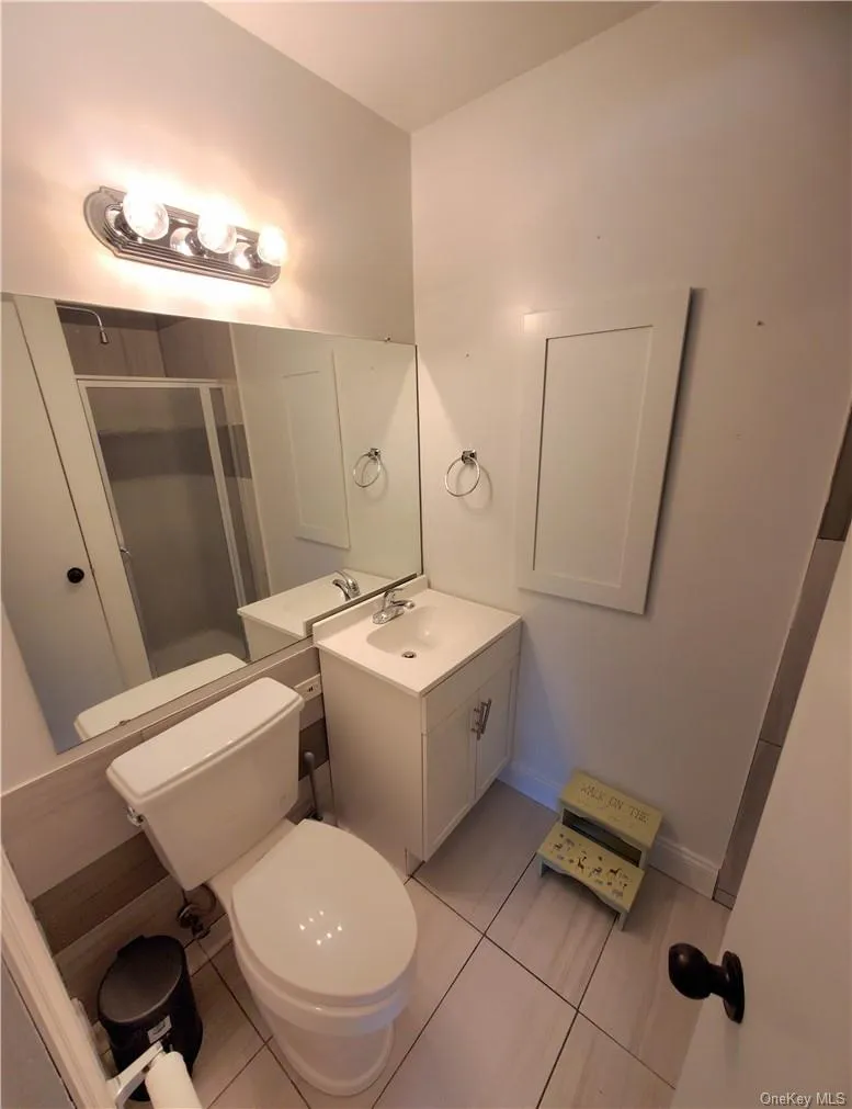 Bathroom featuring tile floors, toilet, and vanity Bathroom featuring tile floors, toilet, and vanity
