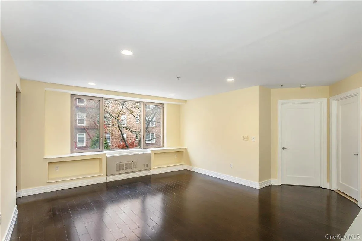 Empty room with dark wood-style flooring and recessed lighting Empty room with dark wood-style flooring and recessed lighting