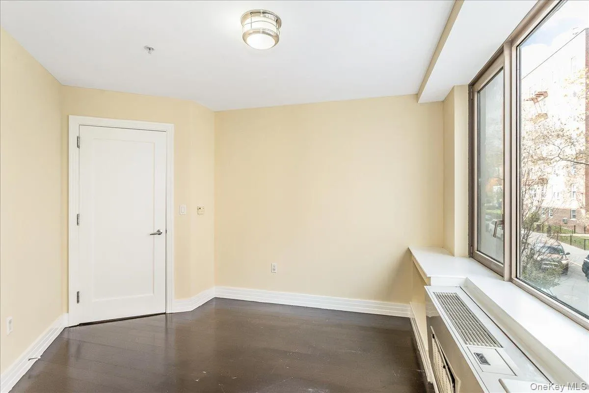 Empty room featuring baseboards and dark wood-style flooring Empty room featuring baseboards and dark wood-style flooring