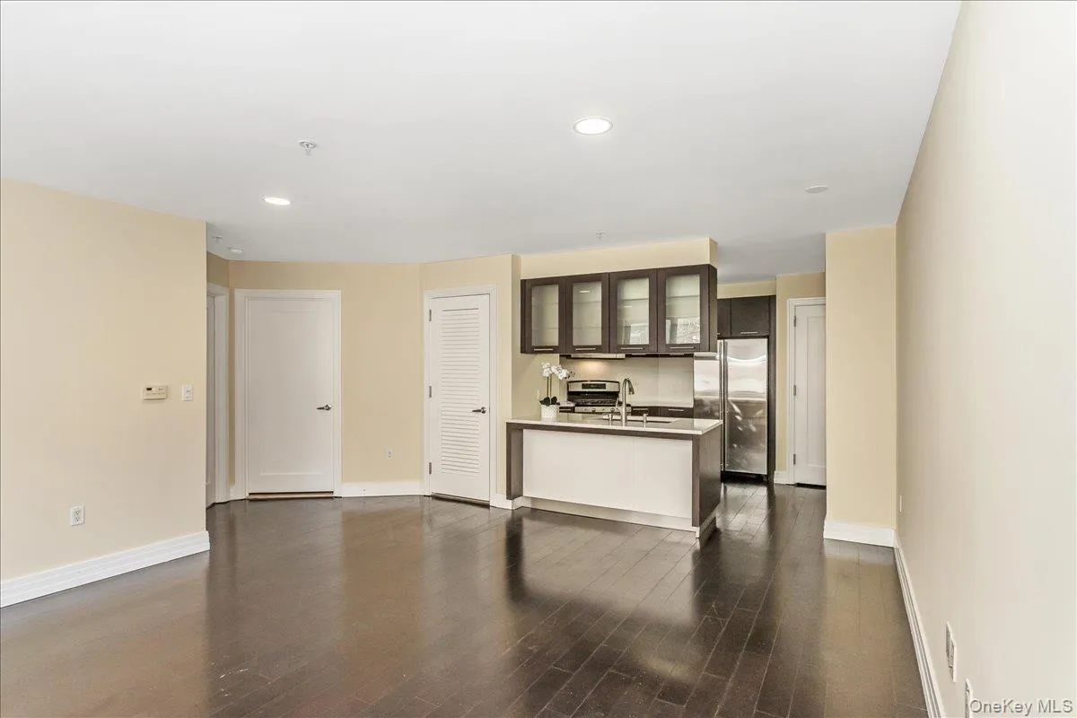 Kitchen with glass insert cabinets, dark brown cabinets, recessed lighting, appliances with stainless steel finishes, and dark wood-style floors Kitchen with glass insert cabinets, dark brown cabinets, recessed lighting, appliances with stainless steel finishes, and dark wood-style floors