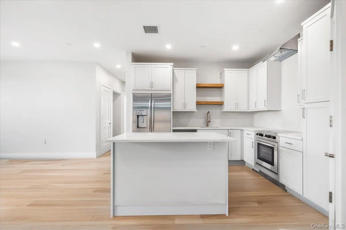 High end gourmet kitchen featuring white cabinets, open shelves, a center island, stainless steel appliances, and open layout for easy everyday living. High end gourmet kitchen featuring white cabinets, open shelves, a center island, stainless steel appliances, and open layout for easy everyday living.