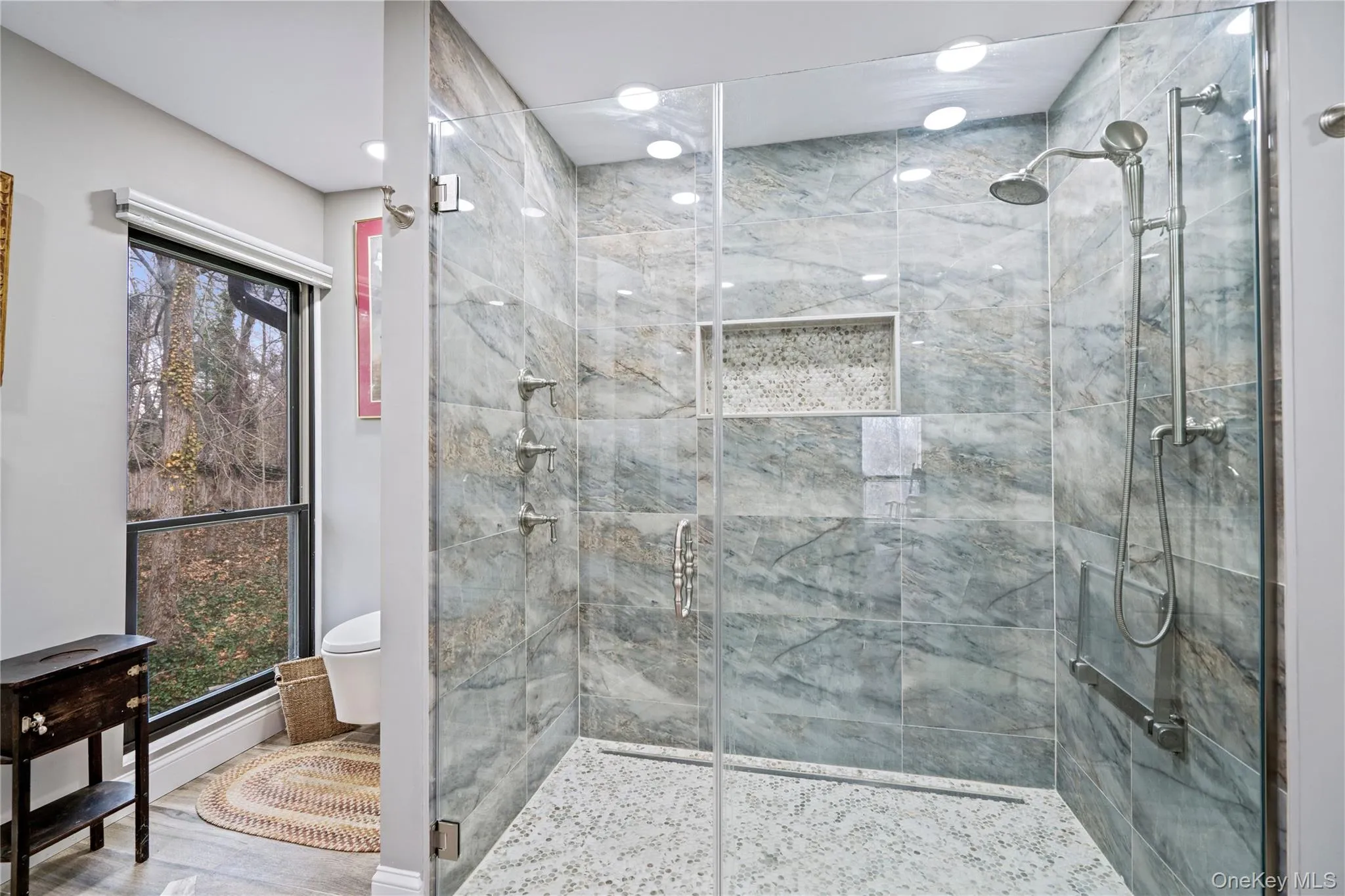 Full bathroom featuring toilet and a marble finish shower Full bathroom featuring toilet and a marble finish shower