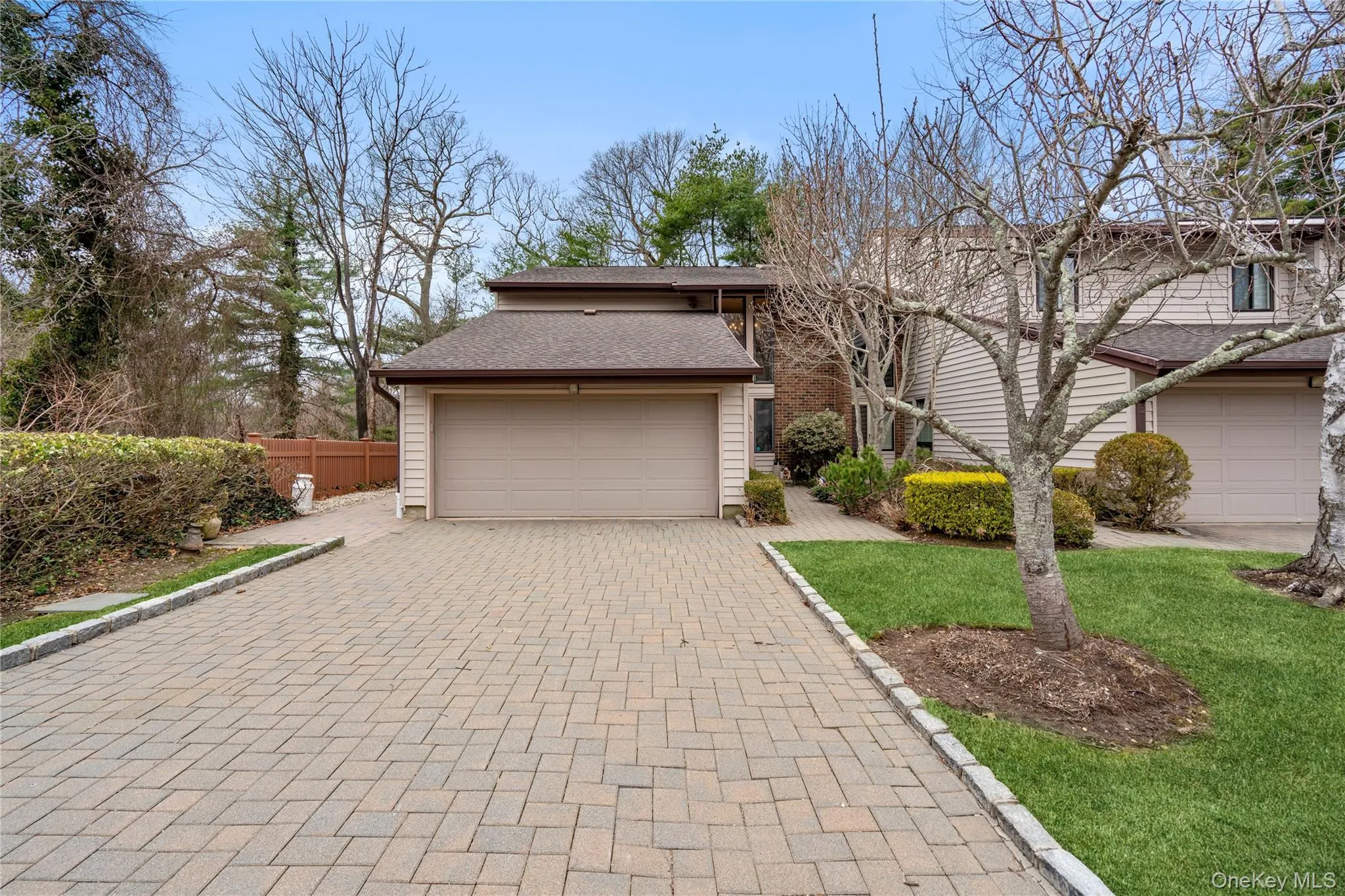 View of front of property featuring decorative driveway, a shingled roof, and an attached garage View of front of property featuring decorative driveway, a shingled roof, and an attached garage