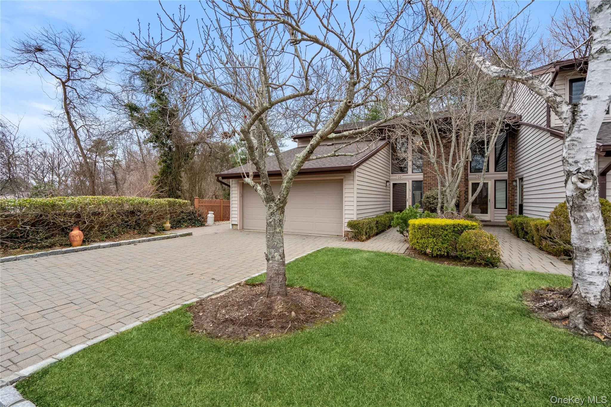 View of front of home featuring decorative driveway, a front yard, and an attached garage View of front of home featuring decorative driveway, a front yard, and an attached garage