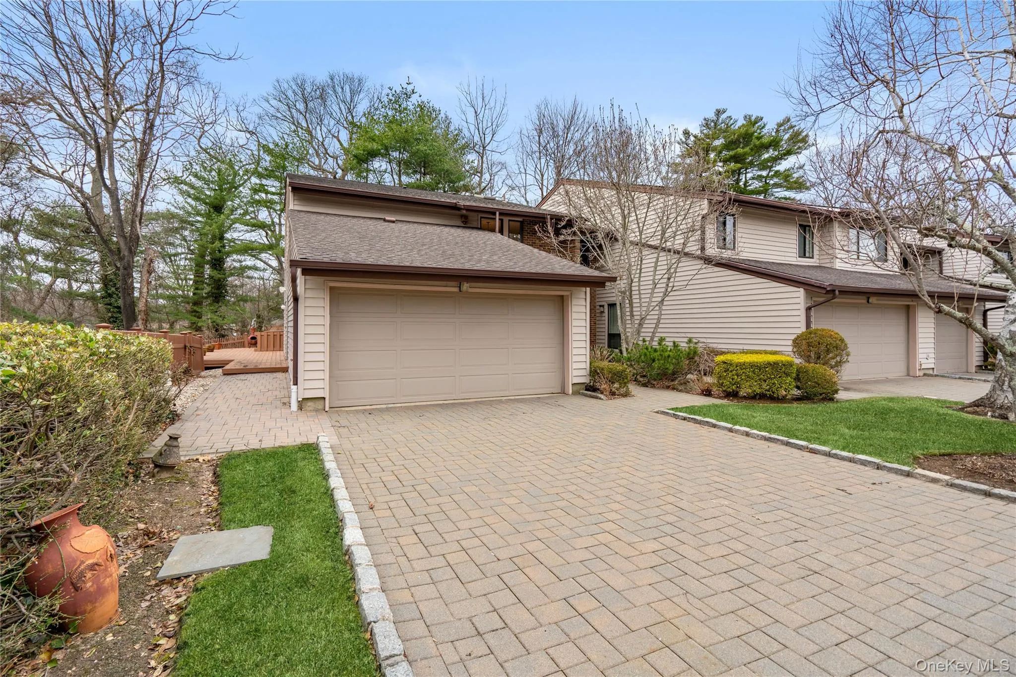 View of front of property with roof with shingles, decorative driveway, and a garage View of front of property with roof with shingles, decorative driveway, and a garage
