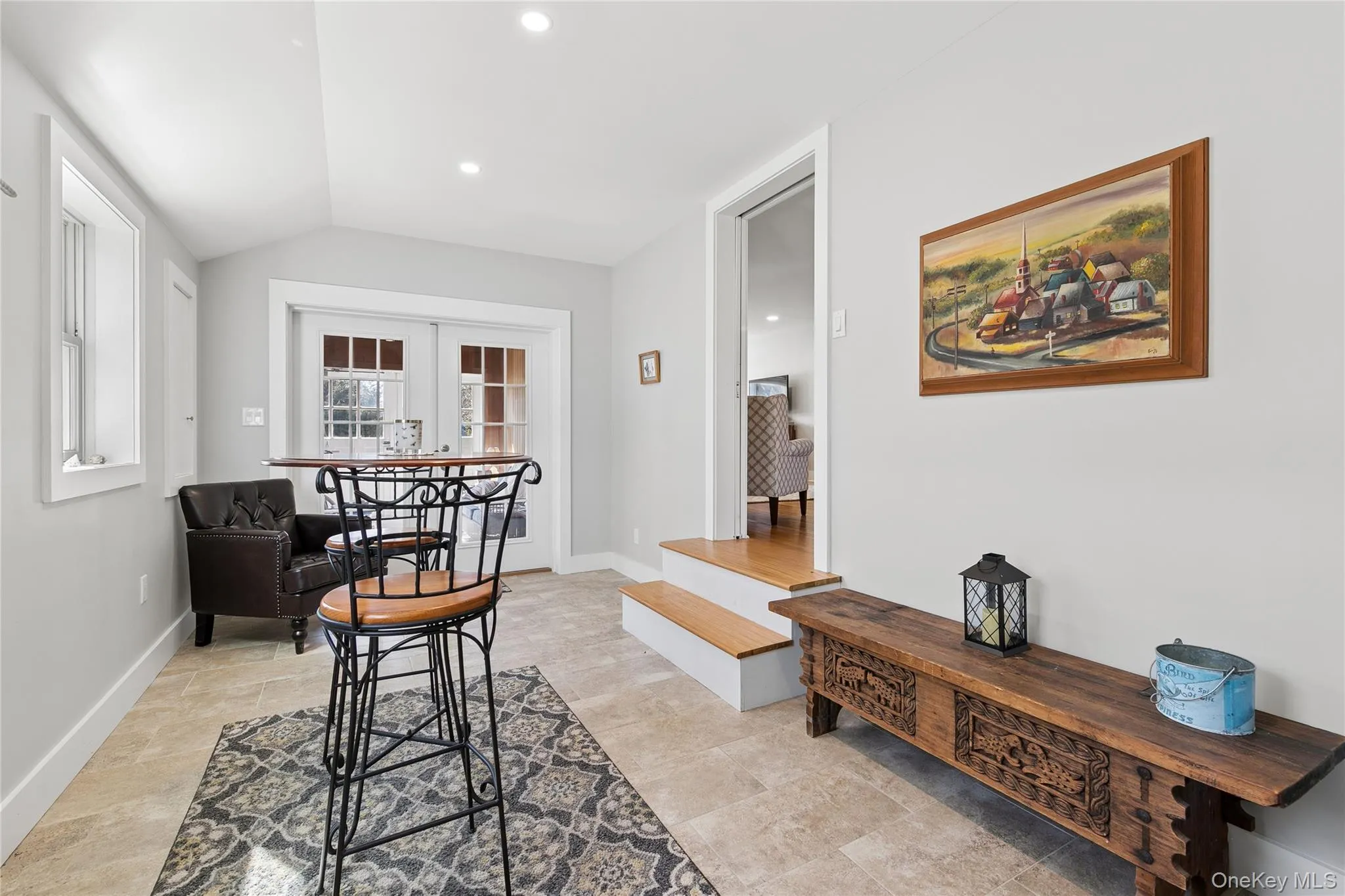 Cozy Sitting Room with Table and Chairs and Free-Standing Wood Burning Stove adjacent to Adjoining Sunroom