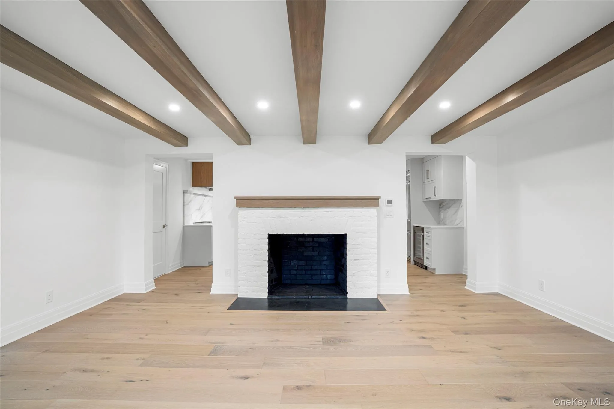 Dining room featuring recessed lighting, light wood-style floors, a fireplace, and beam ceiling Dining room featuring recessed lighting, light wood-style floors, a fireplace, and beam ceiling