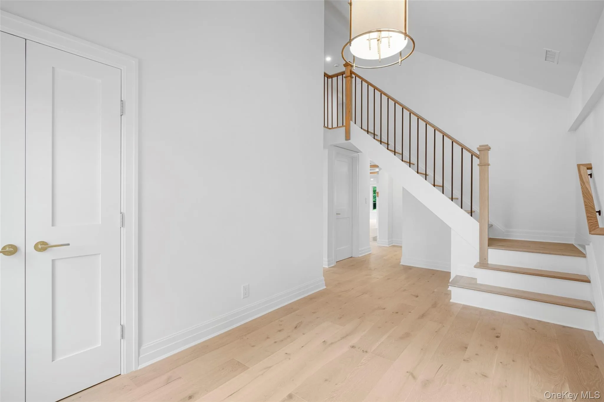 Stairs featuring wood finished floors and a towering ceiling Stairs featuring wood finished floors and a towering ceiling