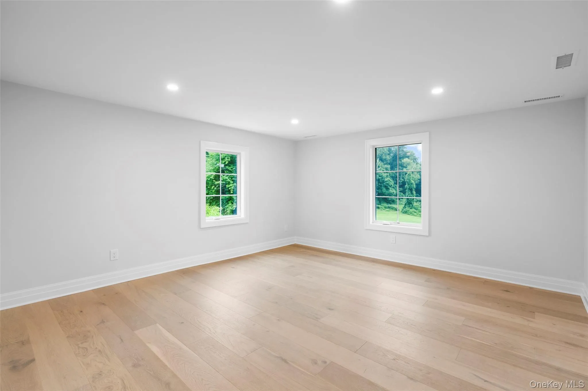 Unfurnished room with light wood-style floors and recessed lighting Unfurnished room with light wood-style floors and recessed lighting