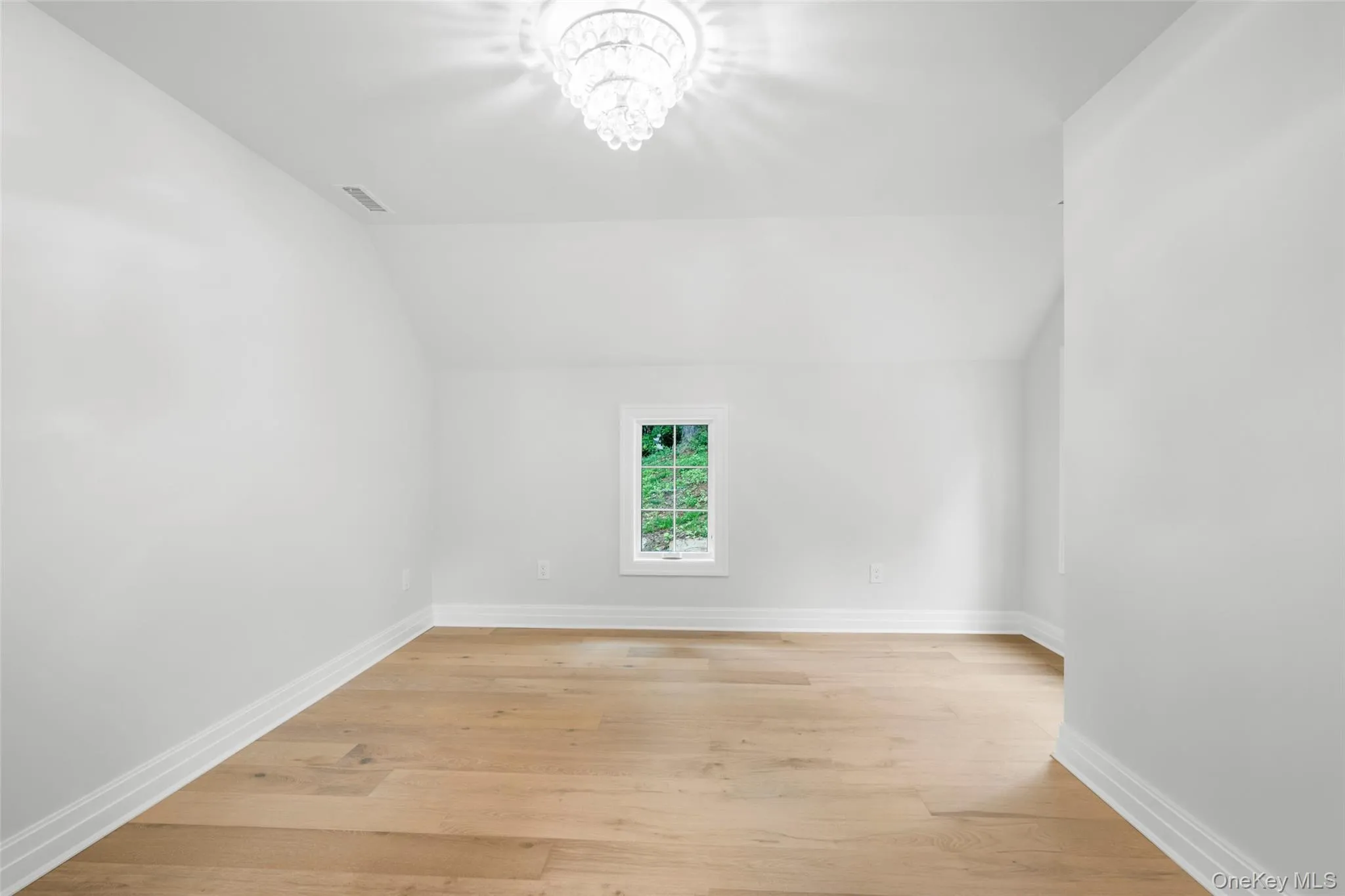 Bedroom with lofted ceiling, a chandelier, and light wood-style flooring Bedroom with lofted ceiling, a chandelier, and light wood-style flooring
