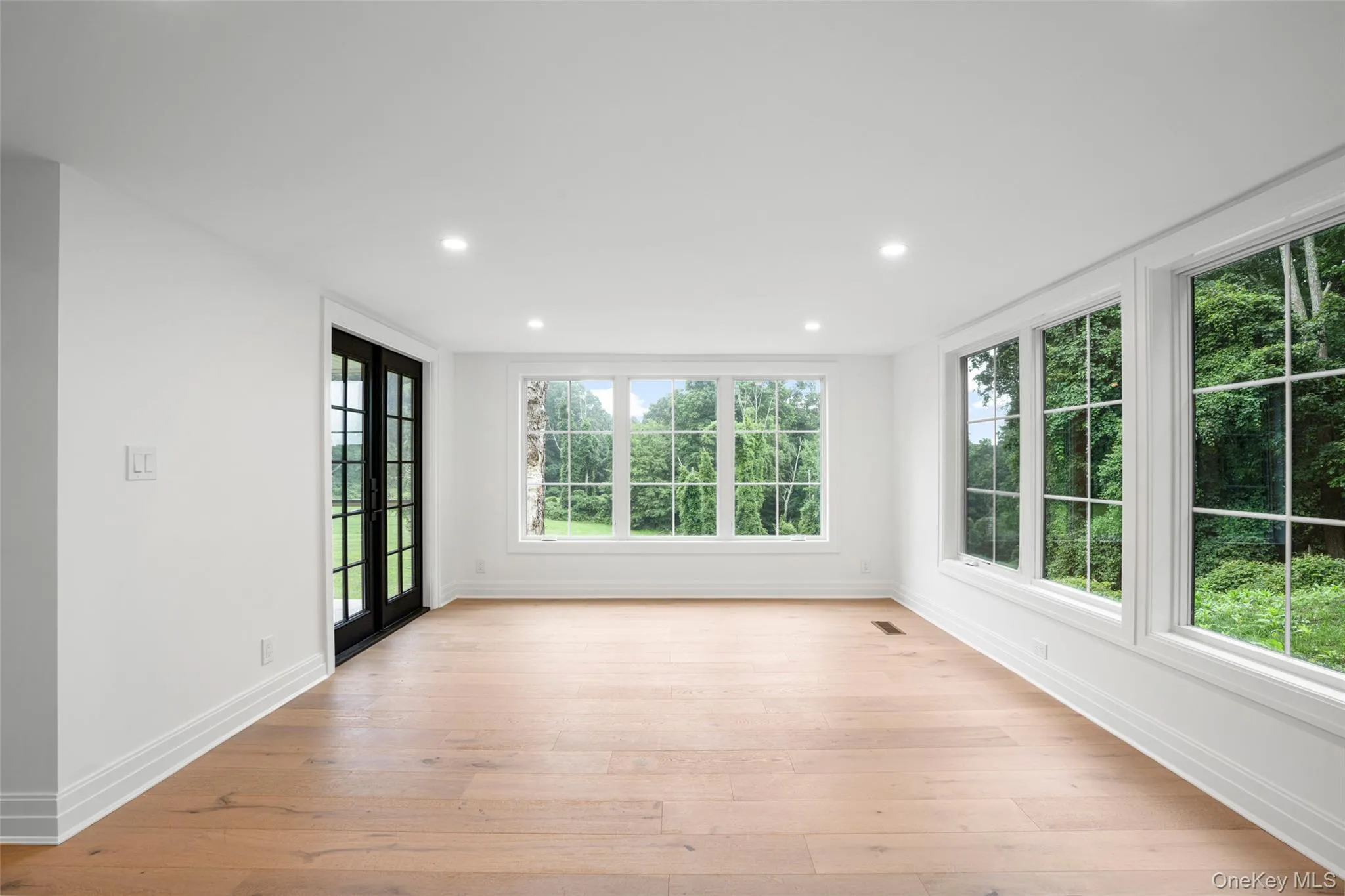 Sun room with light wood-style floors, recessed lighting, large panoramic windows and access to porch Sun room with light wood-style floors, recessed lighting, large panoramic windows and access to porch