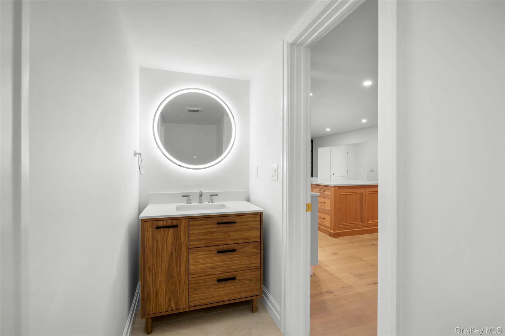 Powder room with vanity, recessed lighting, LED mirror, and wood finished floors Powder room with vanity, recessed lighting, LED mirror, and wood finished floors