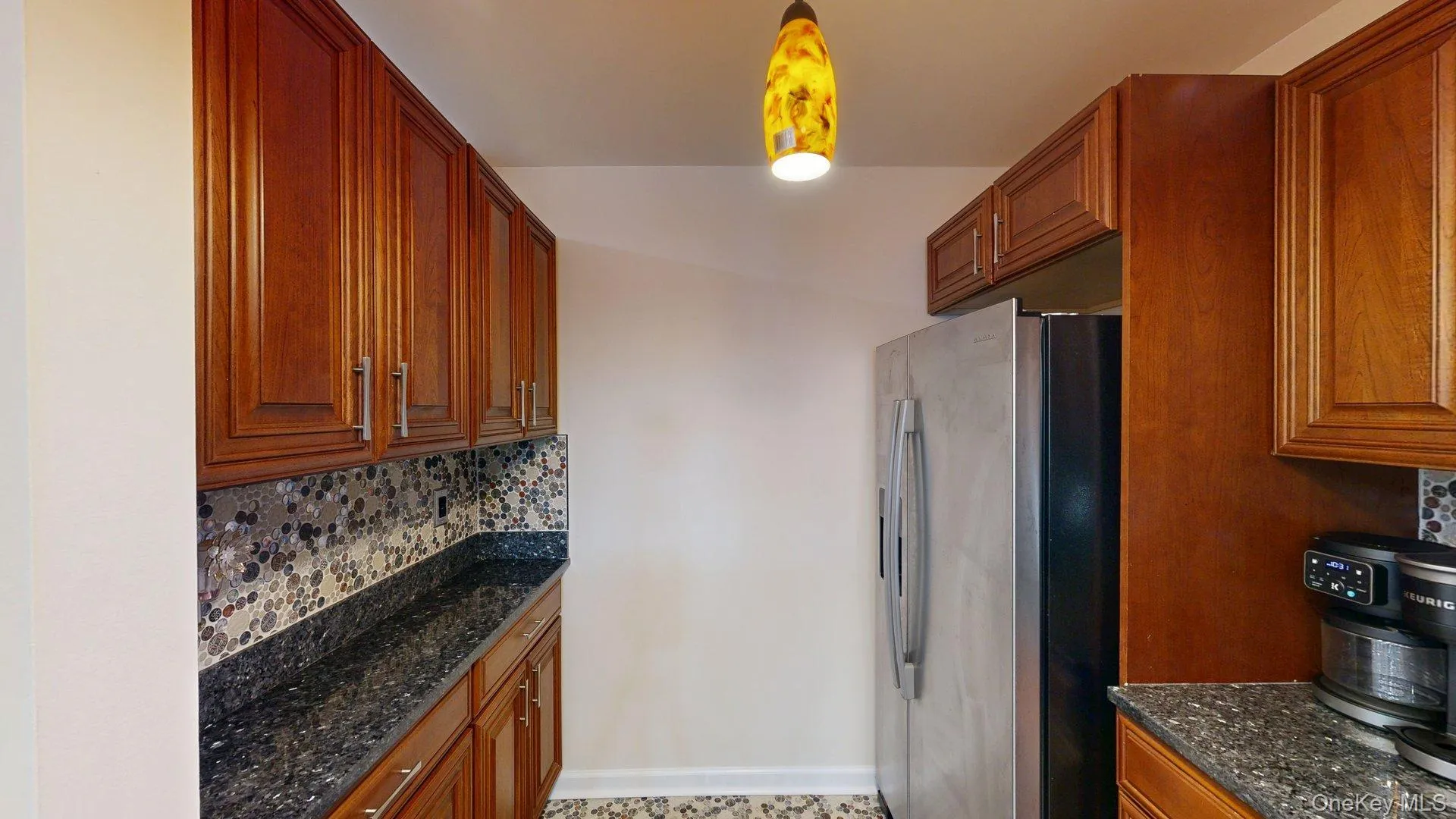 Kitchen featuring w/stainless steel appliances, rich wood cabinetry, beautiful tiled floors, backsplash and gorgeous countertops Kitchen featuring w/stainless steel appliances, rich wood cabinetry, beautiful tiled floors, backsplash and gorgeous countertops