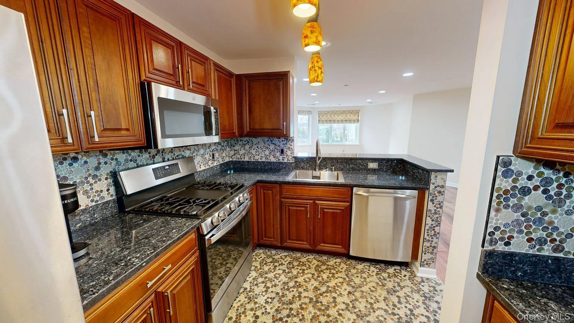Kitchen featuring w/stainless steel appliances, rich wood cabinetry, beautiful tiled floors, backsplash and gorgeous countertops Kitchen featuring w/stainless steel appliances, rich wood cabinetry, beautiful tiled floors, backsplash and gorgeous countertops