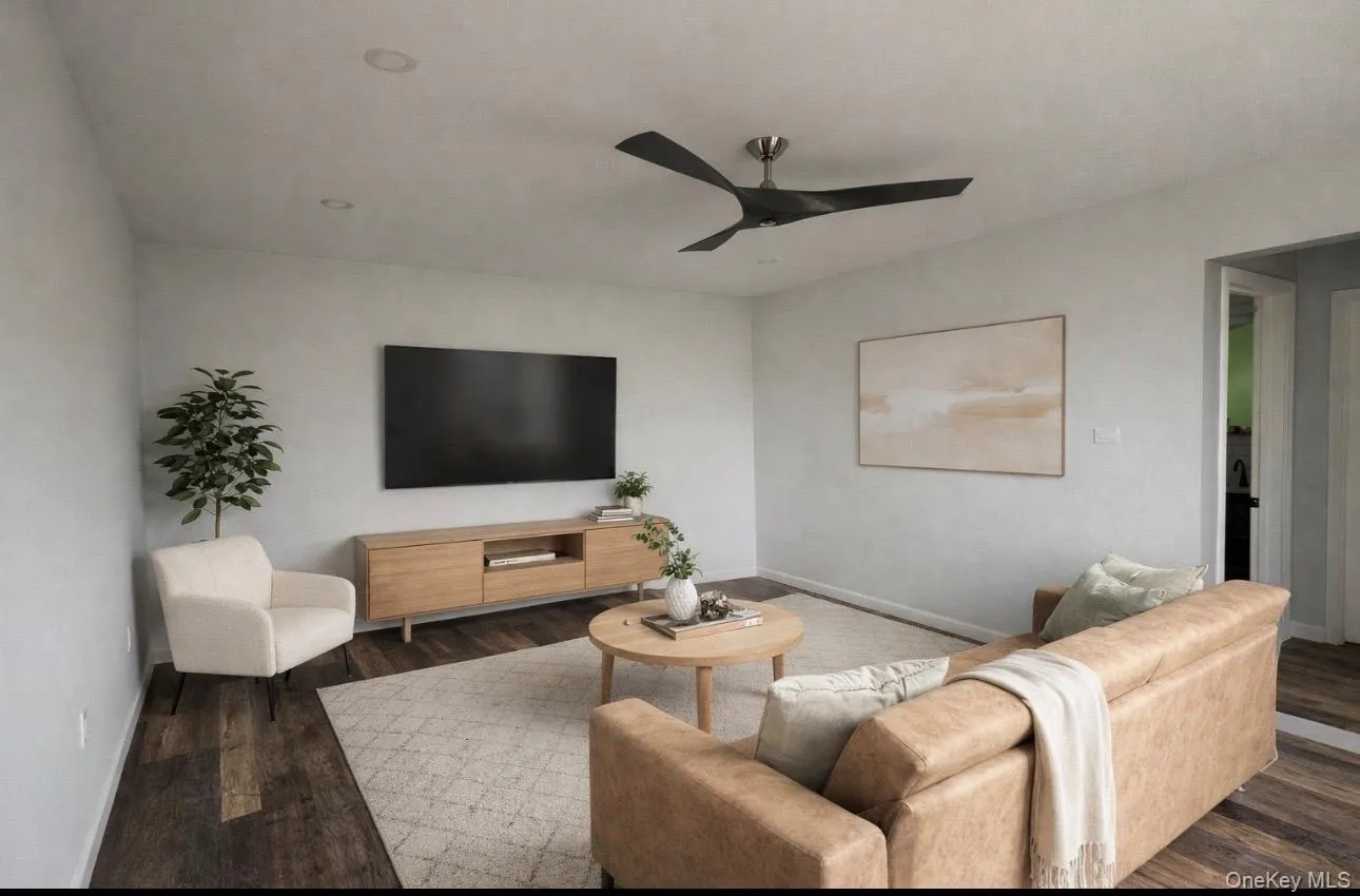 Living room featuring ceiling fan and dark wood-style floors Living room featuring ceiling fan and dark wood-style floors