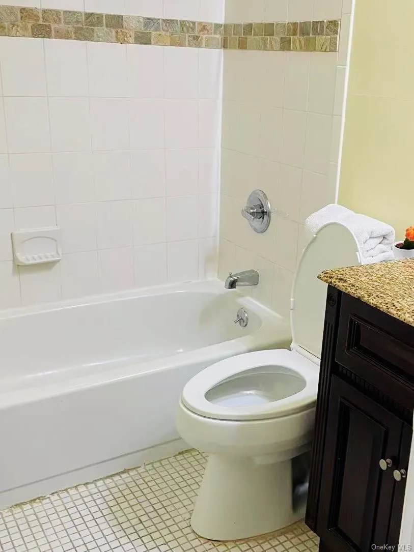 Full bathroom with shower combination, vanity, and tile patterned floors Full bathroom with shower combination, vanity, and tile patterned floors