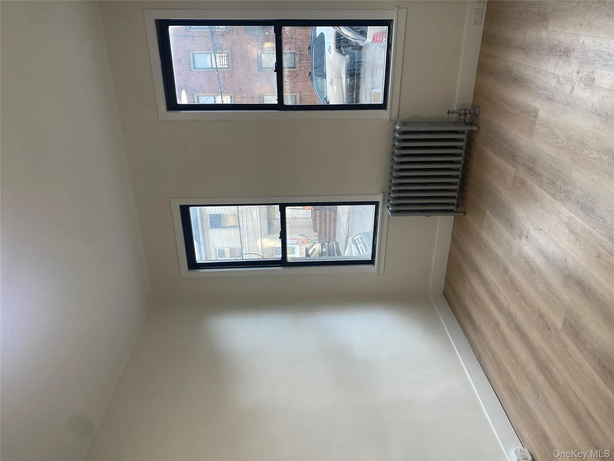 Empty room featuring radiator and light wood-type flooring Empty room featuring radiator and light wood-type flooring