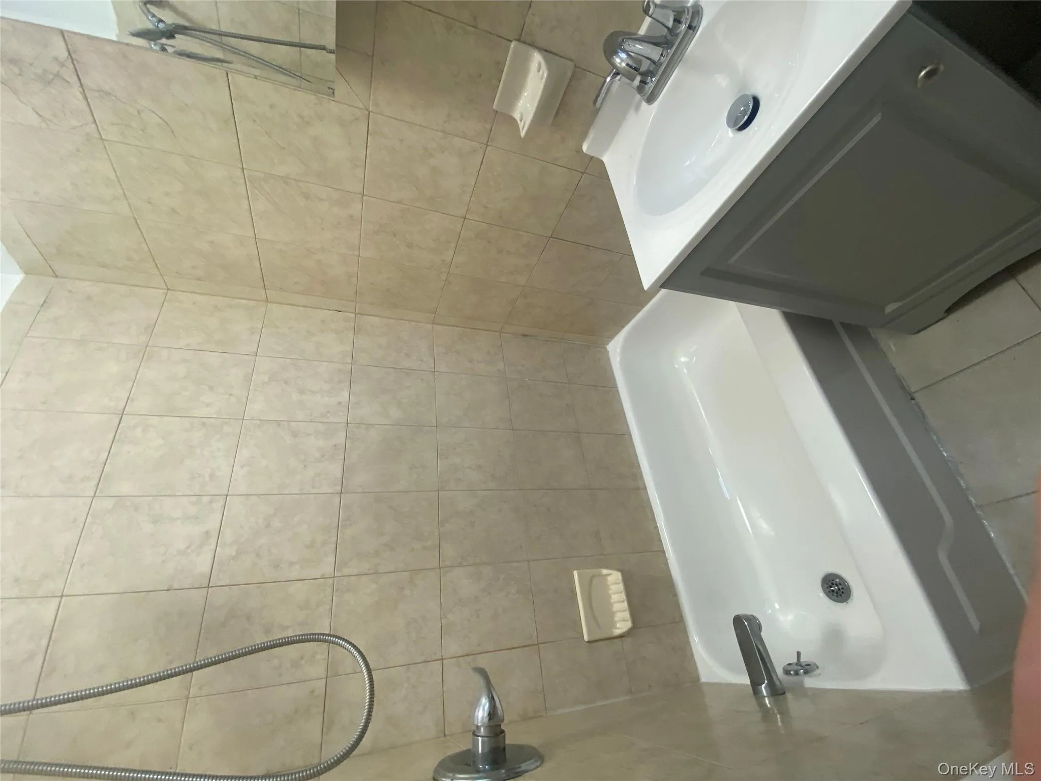 Bathroom with tile walls, vanity, light tile patterned flooring, and tub / shower combination Bathroom with tile walls, vanity, light tile patterned flooring, and tub / shower combination
