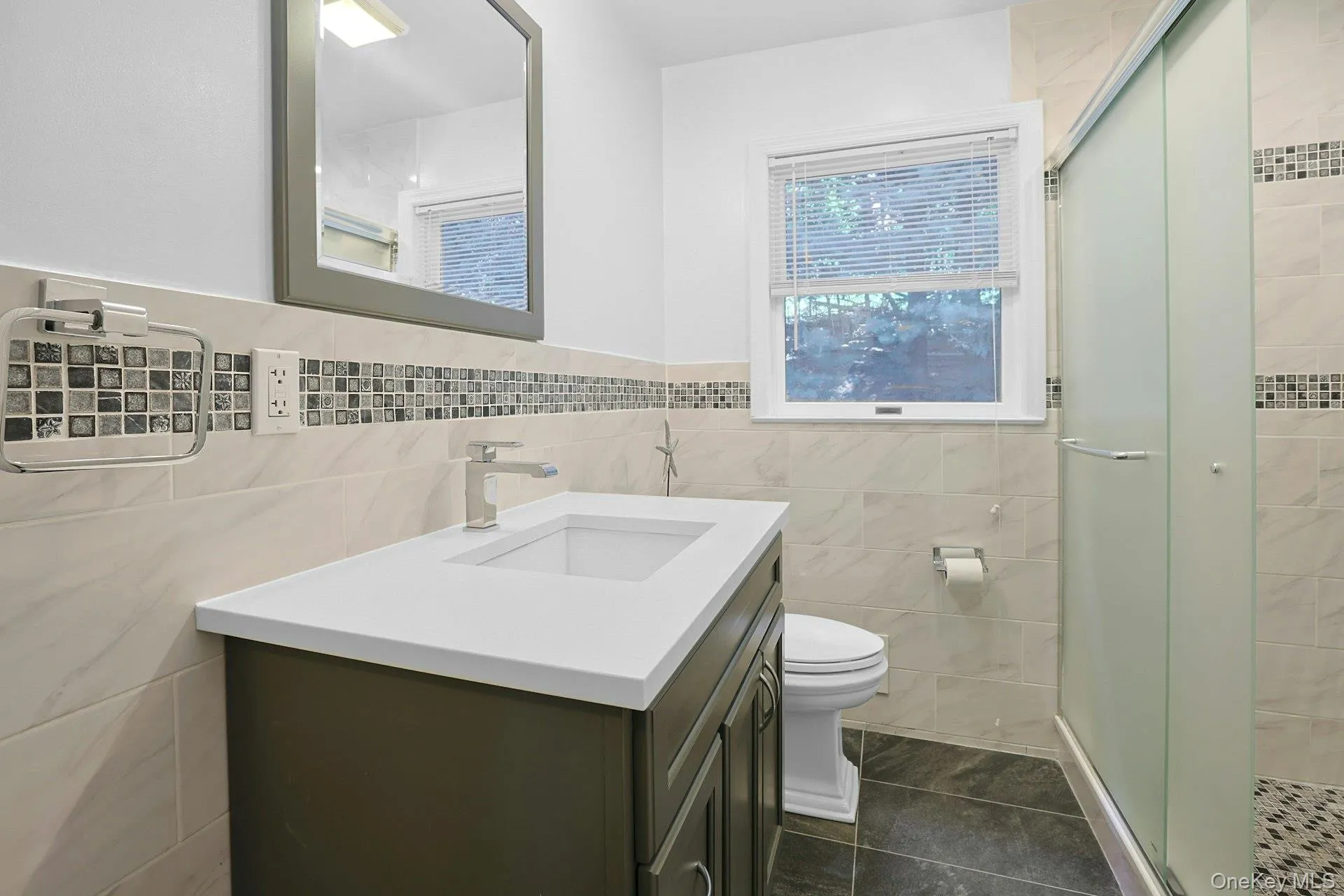 First Floor Bathroom with tiled walls, vanity, shower stall, tile patterned floors, linen closet First Floor Bathroom with tiled walls, vanity, shower stall, tile patterned floors, linen closet