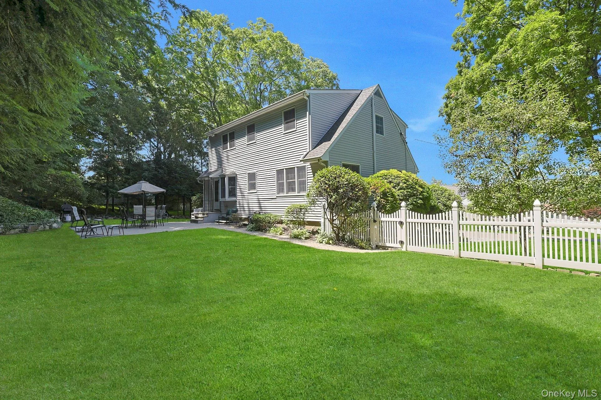 Back of house, manicured yard, paver patio area and paver walkway to gate, entry steps into kitchen Back of house, manicured yard, paver patio area and paver walkway to gate, entry steps into kitchen
