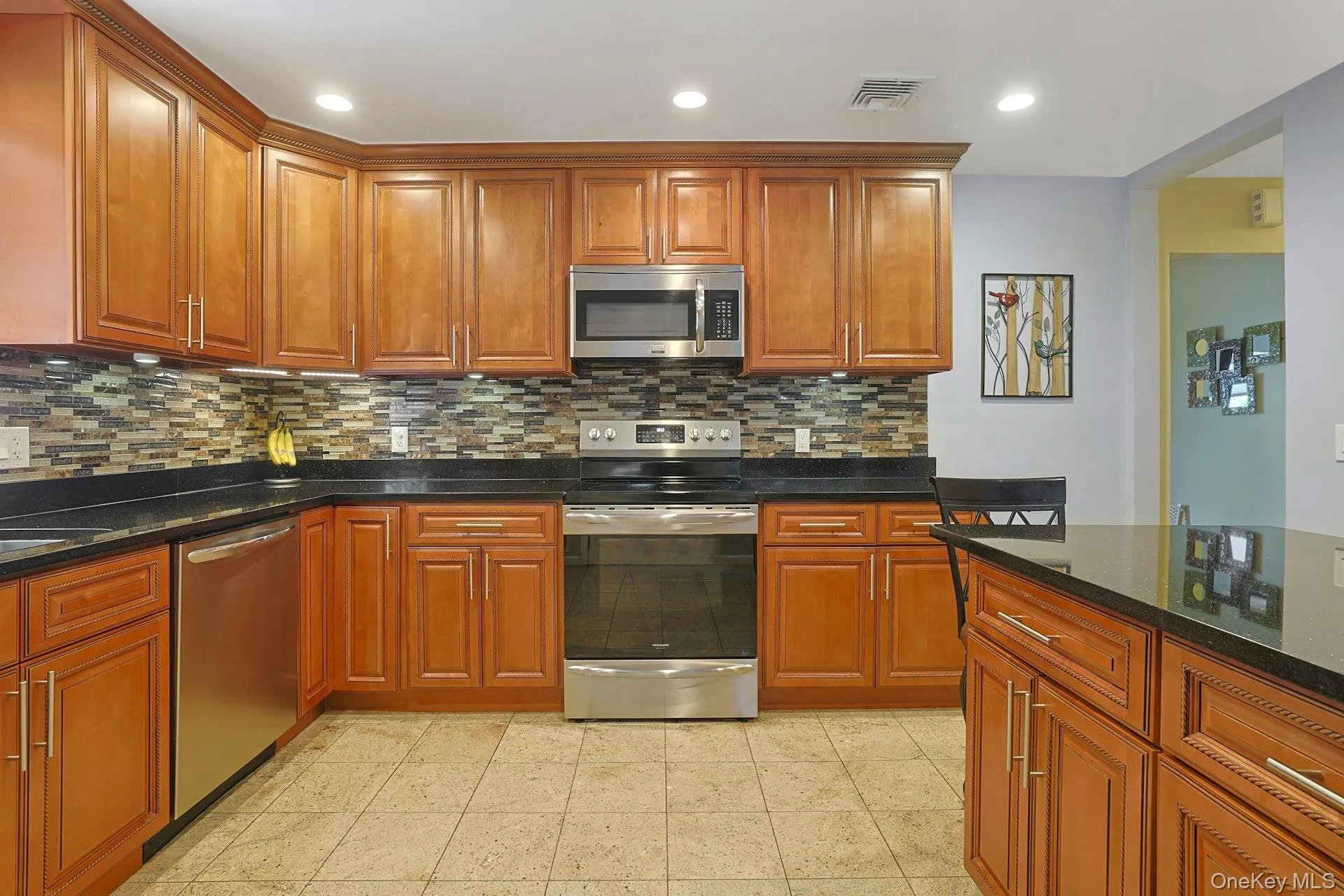 Kitchen view, appliances with stainless steel finishes, decorative backsplash, granite counters, recessed lighting, and wood cabinets Kitchen view, appliances with stainless steel finishes, decorative backsplash, granite counters, recessed lighting, and wood cabinets