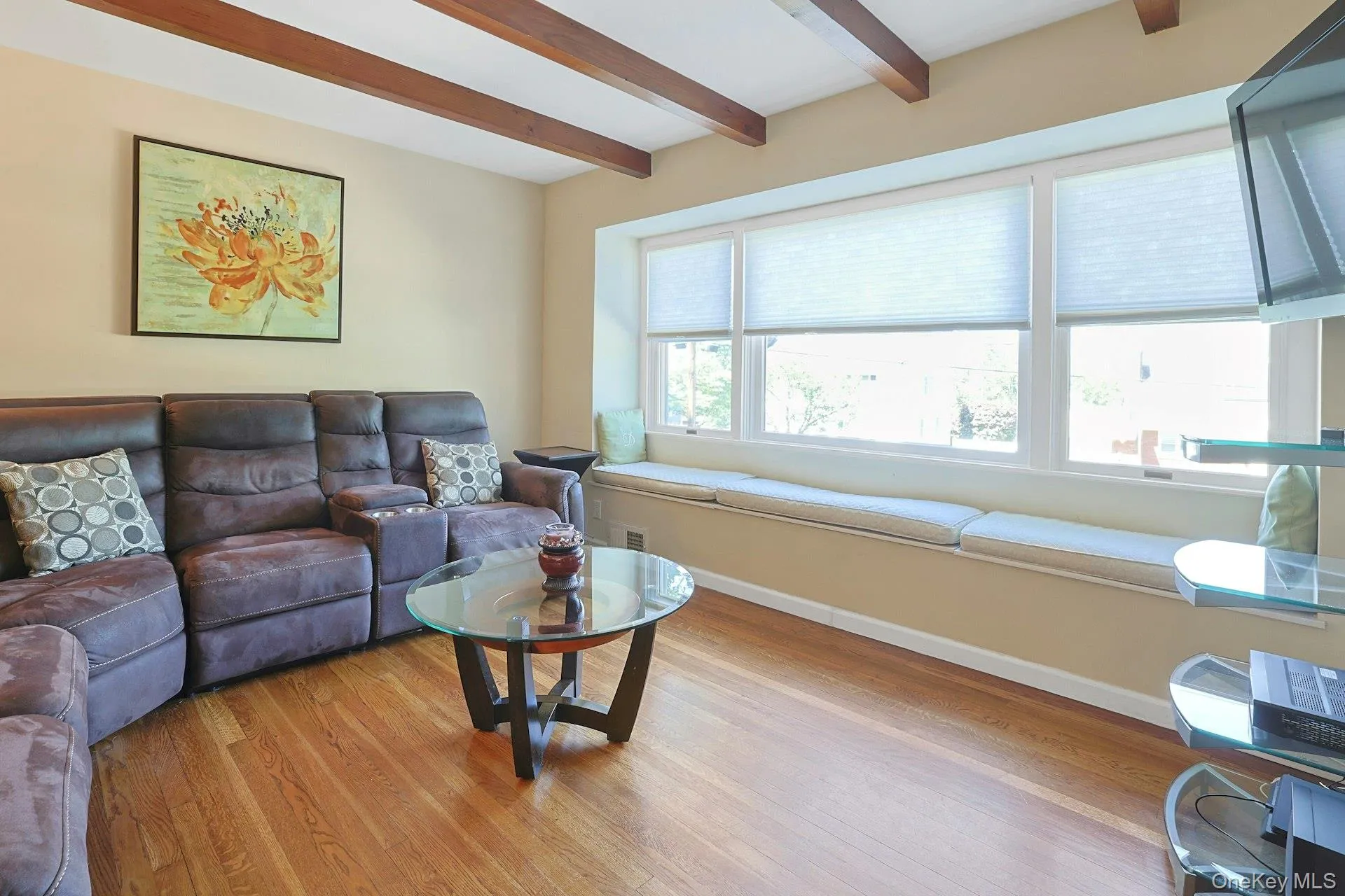 Family Room, featuring beamed ceiling, hardwood floors, and window seat Family Room, featuring beamed ceiling, hardwood floors, and window seat