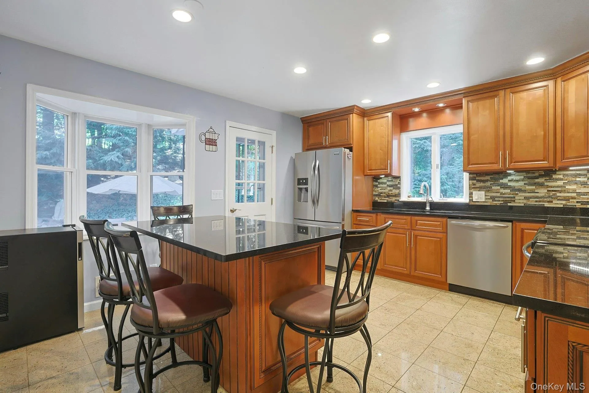 Modern Eat-in Kitchen featuring stainless steel appliances, tasteful backsplash, granite floor, granite counters, movable kitchen island, and recessed lighting Modern Eat-in Kitchen featuring stainless steel appliances, tasteful backsplash, granite floor, granite counters, movable kitchen island, and recessed lighting