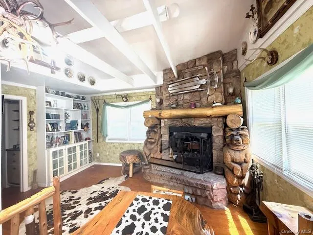 Living room beam ceiling, a stone fireplace, and wood floors Living room beam ceiling, a stone fireplace, and wood floors