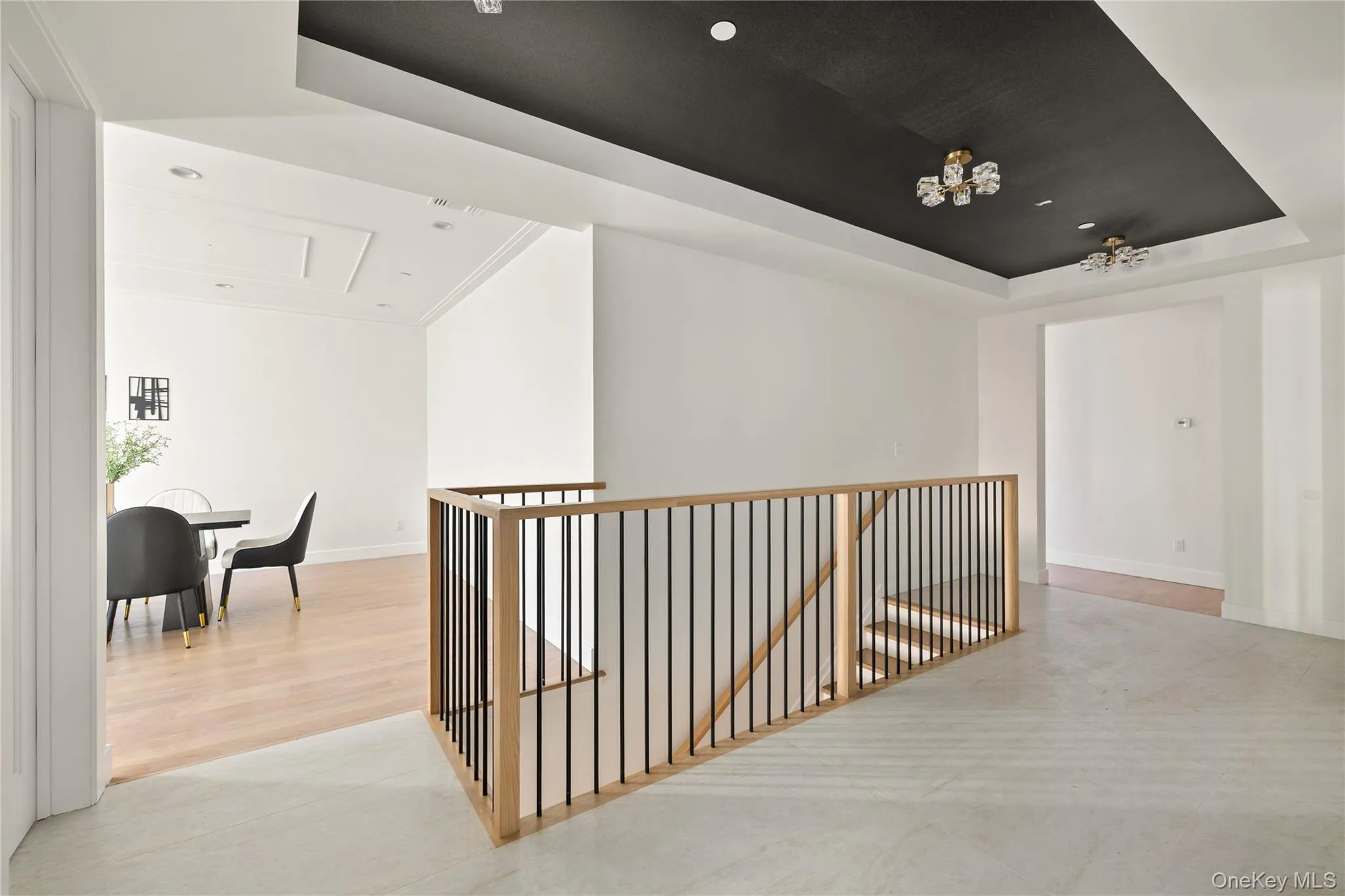 Hall featuring a raised ceiling, an upstairs landing, recessed lighting, and light wood-type flooring Hall featuring a raised ceiling, an upstairs landing, recessed lighting, and light wood-type flooring