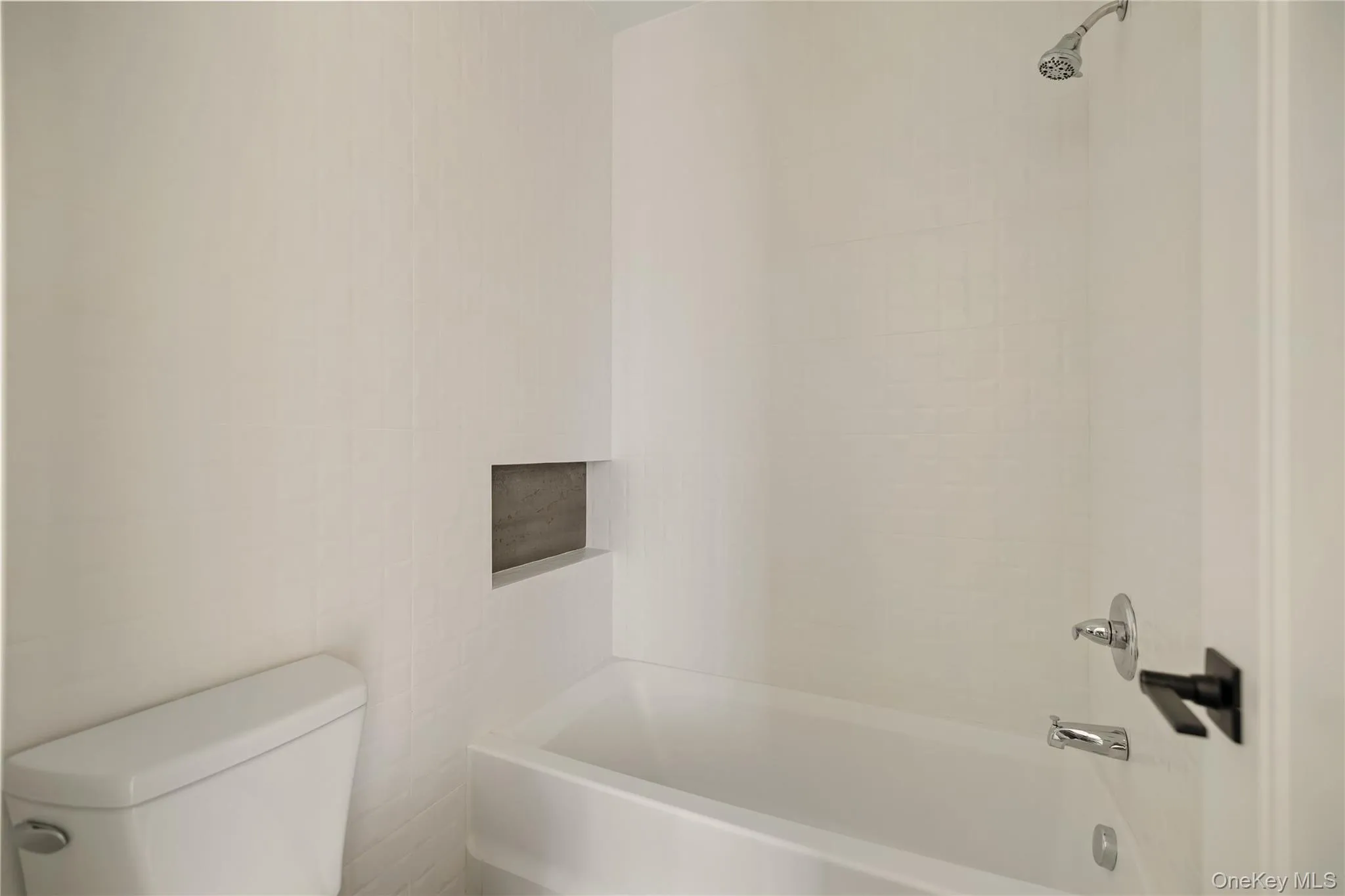 Bathroom featuring tub / shower combination and toilet Bathroom featuring tub / shower combination and toilet