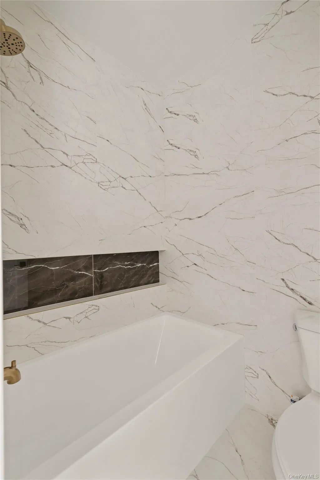 Full bath with toilet and marble tiled floors Full bath with toilet and marble tiled floors