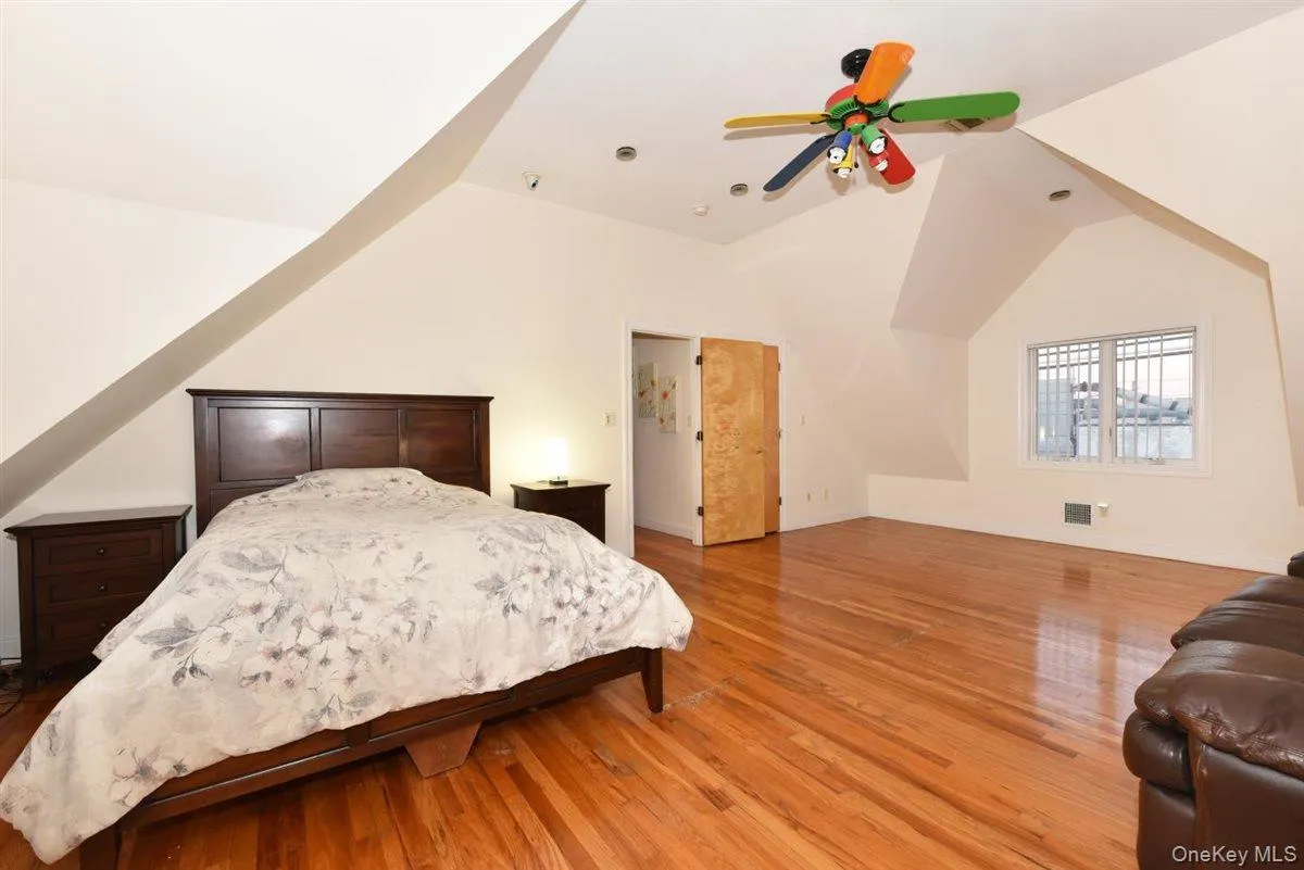 Bedroom with vaulted ceiling, light wood-style flooring, and a ceiling fan Bedroom with vaulted ceiling, light wood-style flooring, and a ceiling fan