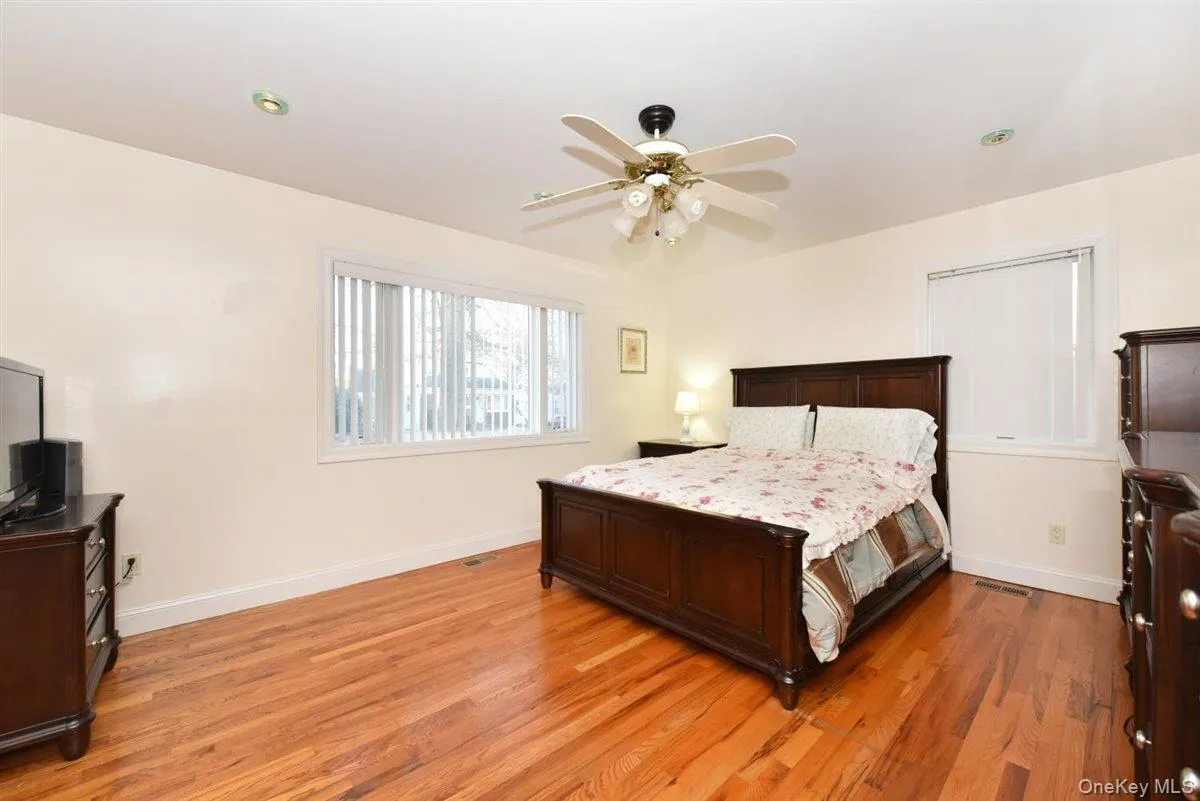 Bedroom with ceiling fan and light wood-type flooring Bedroom with ceiling fan and light wood-type flooring