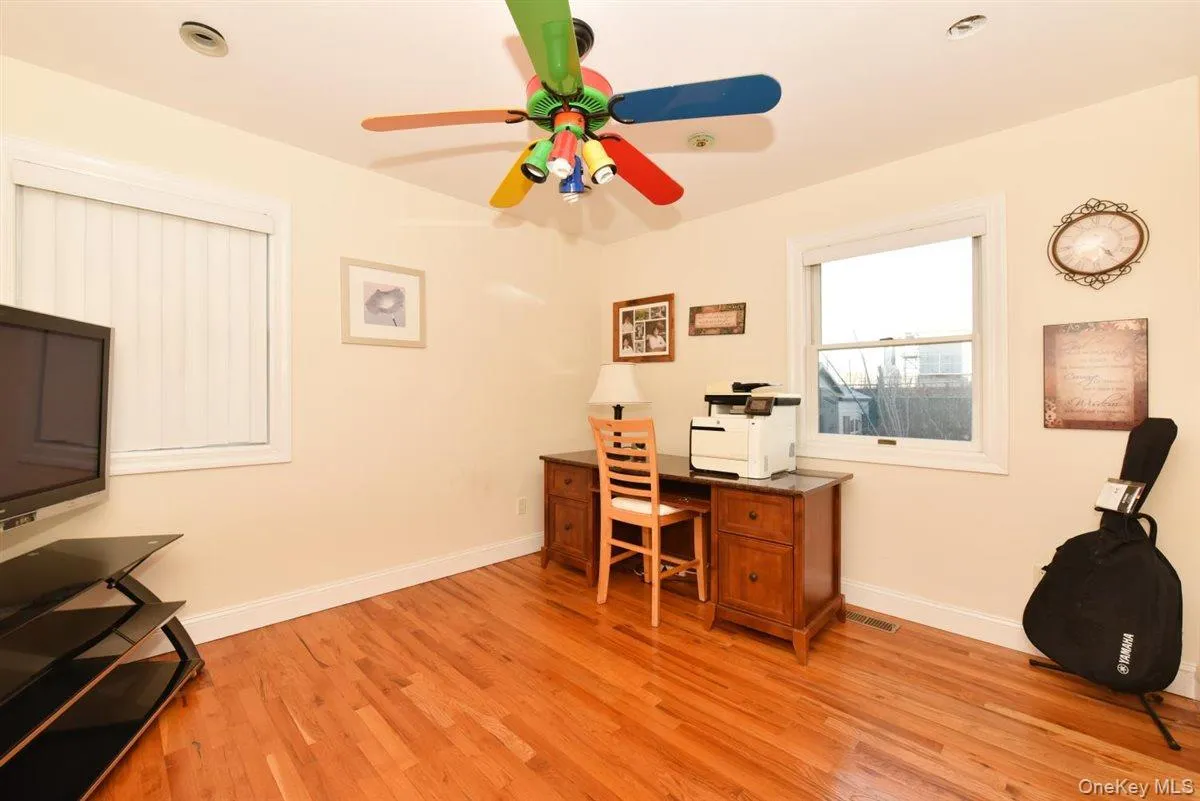 Office area with light wood finished floors and a ceiling fan Office area with light wood finished floors and a ceiling fan