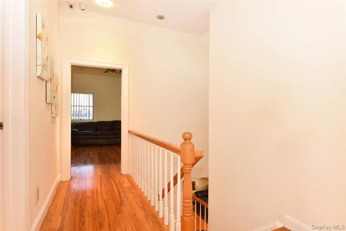 Corridor with light wood-type flooring and an upstairs landing Corridor with light wood-type flooring and an upstairs landing