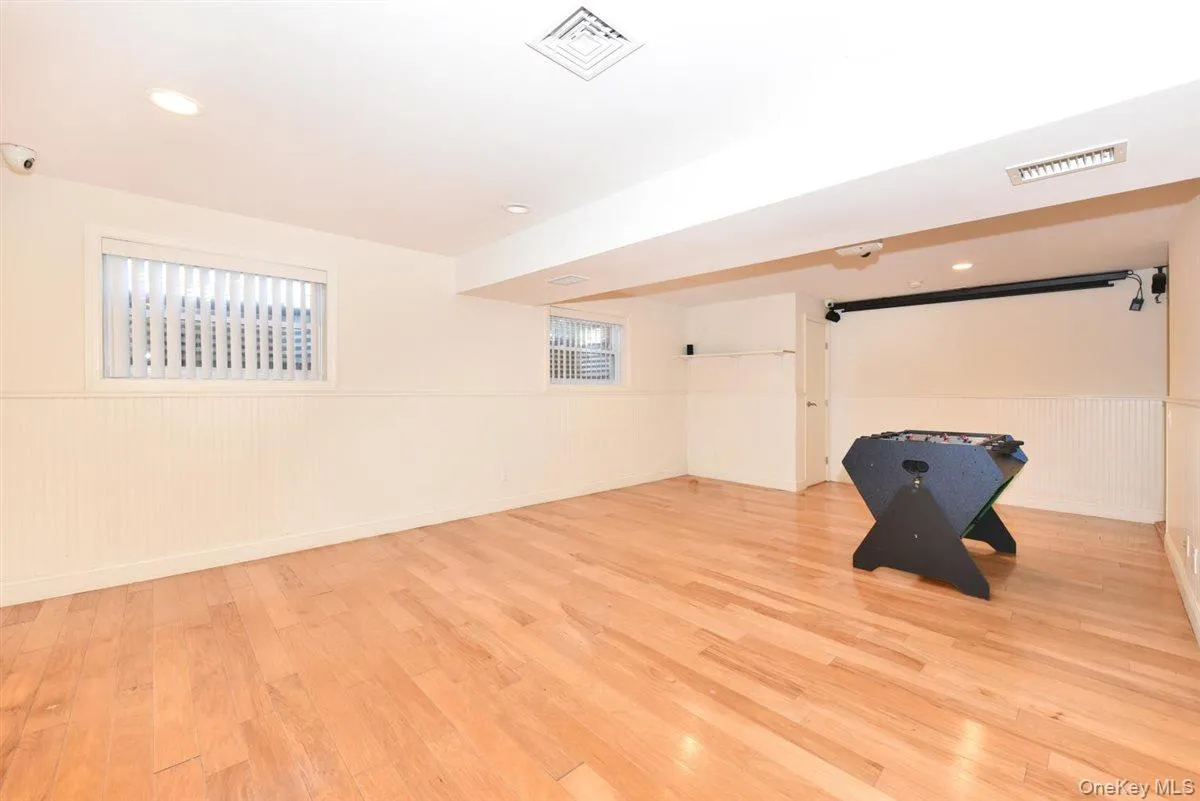 Below grade area with wainscoting, light wood-style floors, and recessed lighting Below grade area with wainscoting, light wood-style floors, and recessed lighting