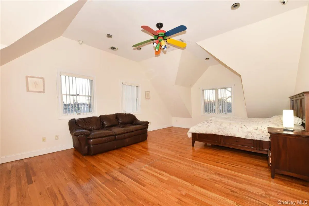 Bedroom with light wood-type flooring, ceiling fan, and vaulted ceiling Bedroom with light wood-type flooring, ceiling fan, and vaulted ceiling