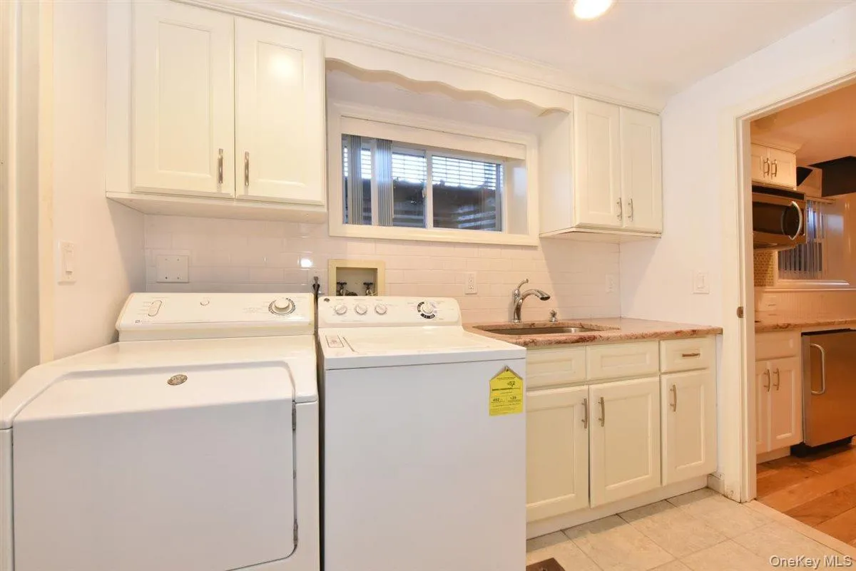 Laundry room featuring washer and dryer, cabinet space, and light tile patterned floors Laundry room featuring washer and dryer, cabinet space, and light tile patterned floors