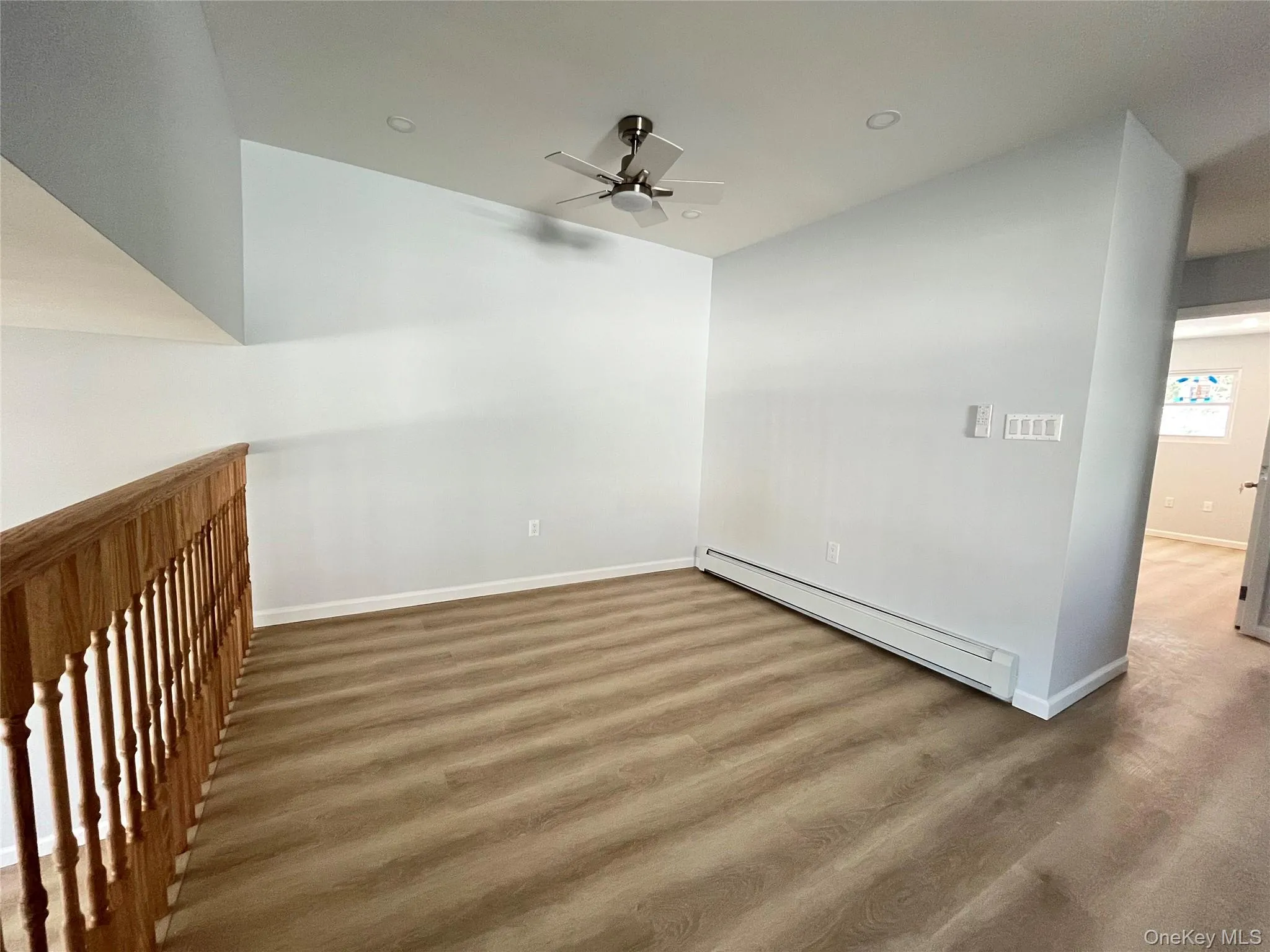 Room with baseboard heating, a ceiling fan, wood finished floors, and recessed lighting Room with baseboard heating, a ceiling fan, wood finished floors, and recessed lighting
