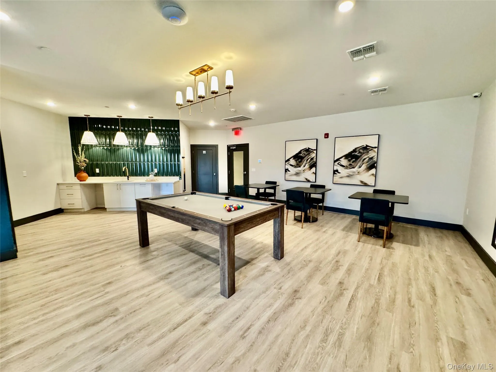 Playroom featuring pool table, light hardwood / wood-style flooring, and wet bar Playroom featuring pool table, light hardwood / wood-style flooring, and wet bar