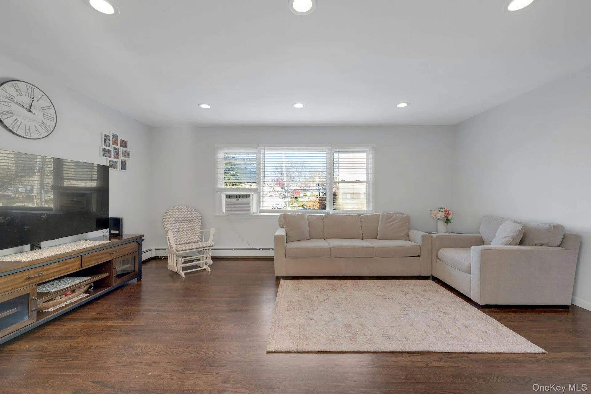 Living room with cooling unit and dark hardwood / wood-style floors Living room with cooling unit and dark hardwood / wood-style floors
