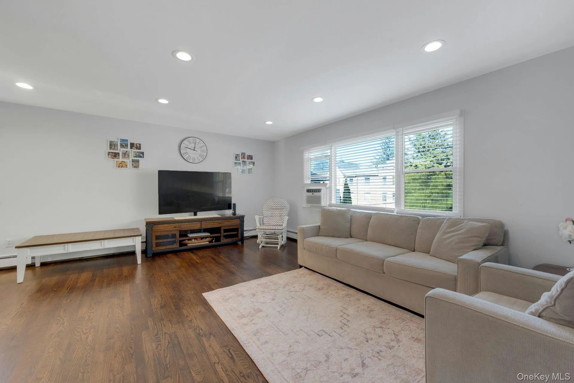 Living room featuring dark hardwood / wood-style floors and a baseboard radiator Living room featuring dark hardwood / wood-style floors and a baseboard radiator