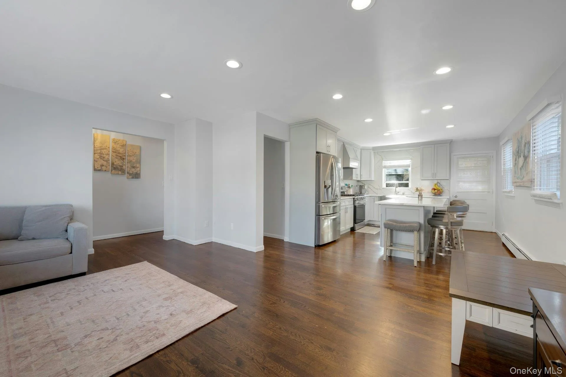Living room featuring dark hardwood / wood-style floors and a baseboard heating unit Living room featuring dark hardwood / wood-style floors and a baseboard heating unit