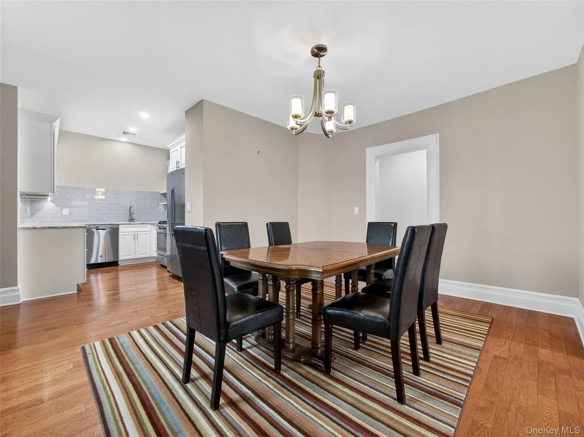 Dining space featuring light wood-style floors and suspended lighting Dining space featuring light wood-style floors and suspended lighting