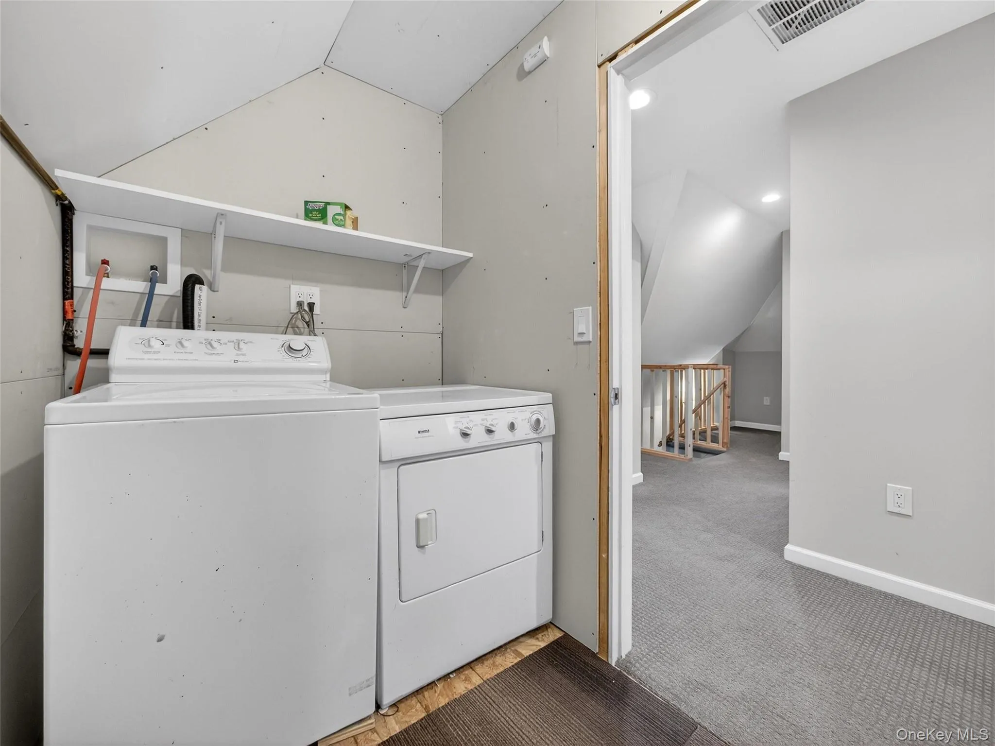 Laundry room with vaulted ceiling, light carpet, and independent washer and dryer Laundry room with vaulted ceiling, light carpet, and independent washer and dryer