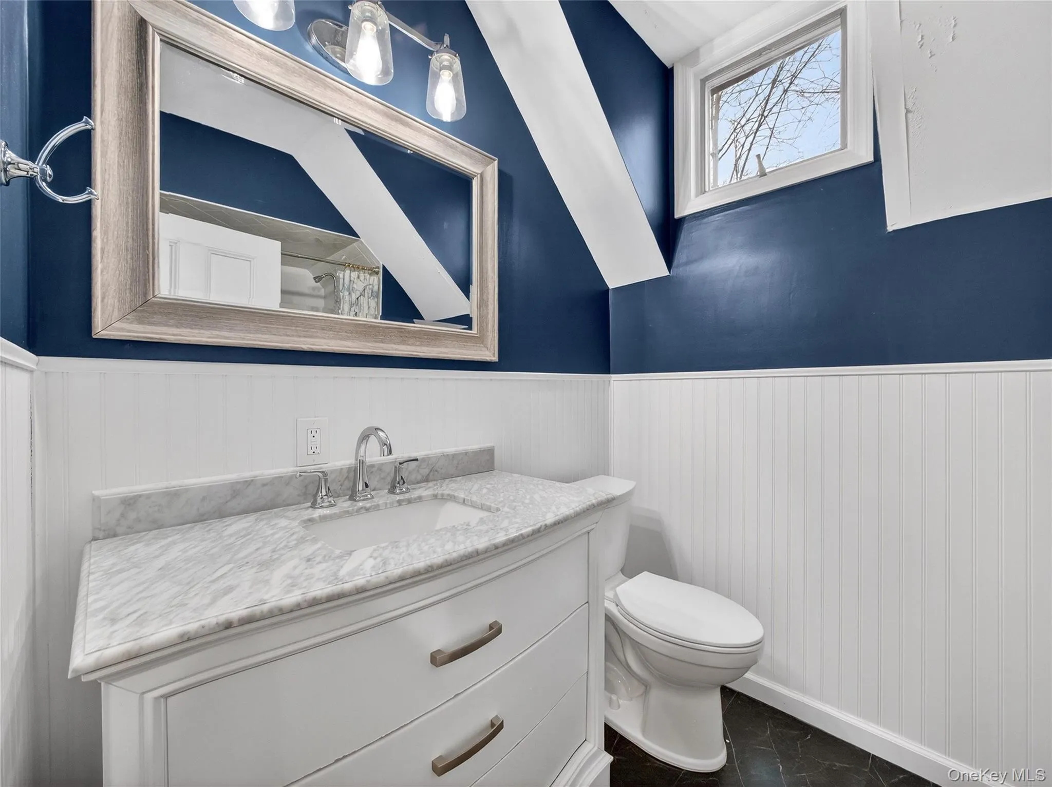 Half bath featuring vanity and wainscoting Half bath featuring vanity and wainscoting