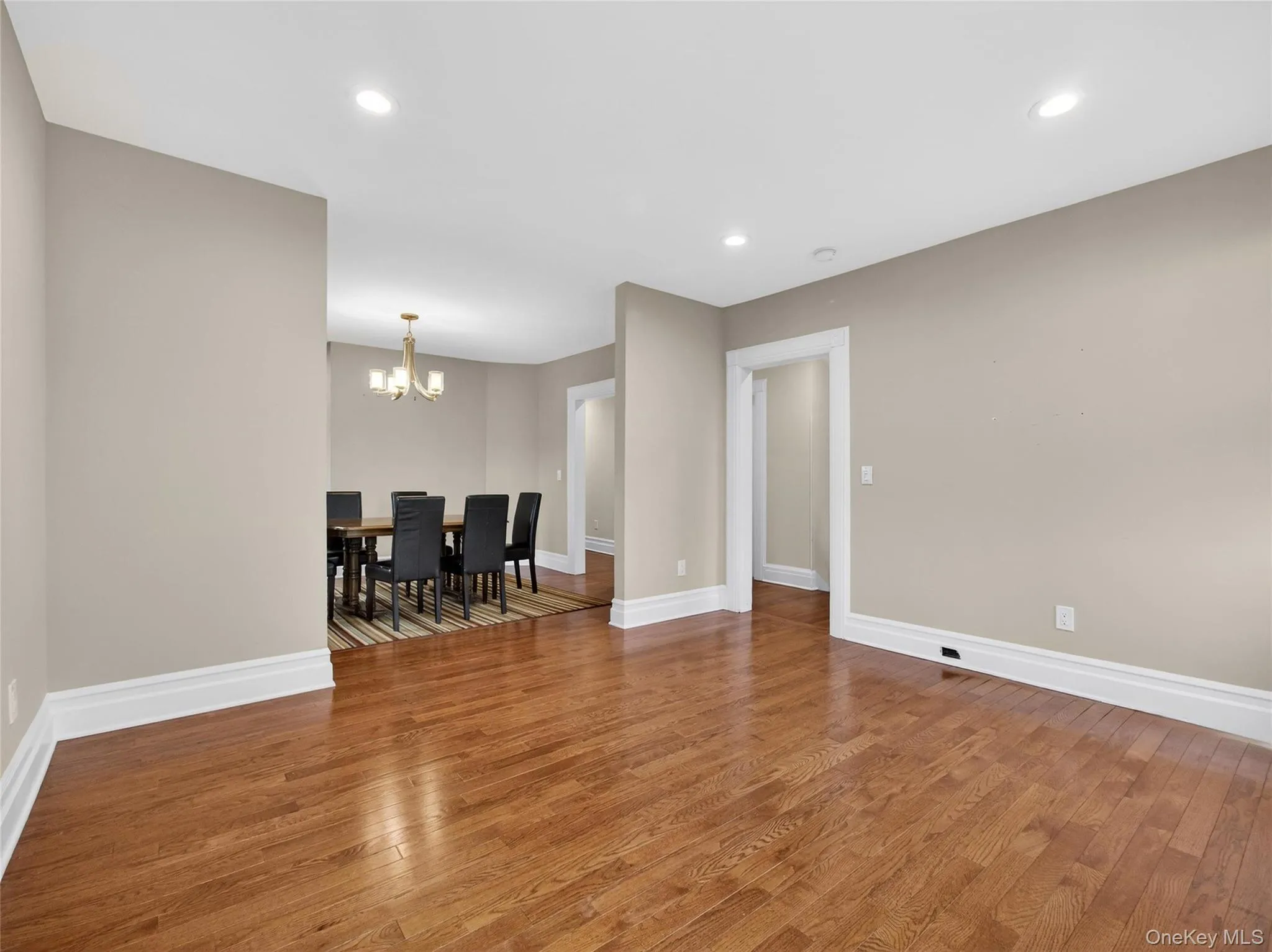 Spare room featuring wood-type flooring and hanging lights Spare room featuring wood-type flooring and hanging lights