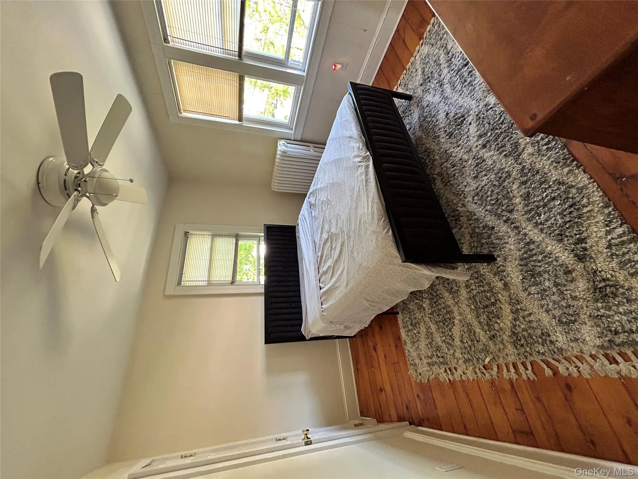 Bedroom featuring wood-type flooring, baseboards, and ceiling fan Bedroom featuring wood-type flooring, baseboards, and ceiling fan